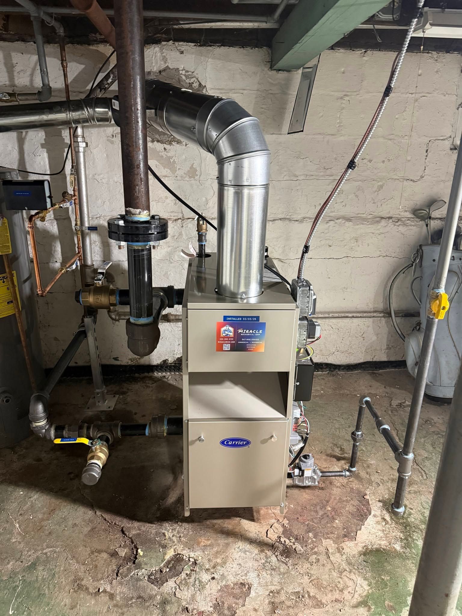 Basement utility room with a furnace, silver ductwork, pipes, and exposed concrete walls.