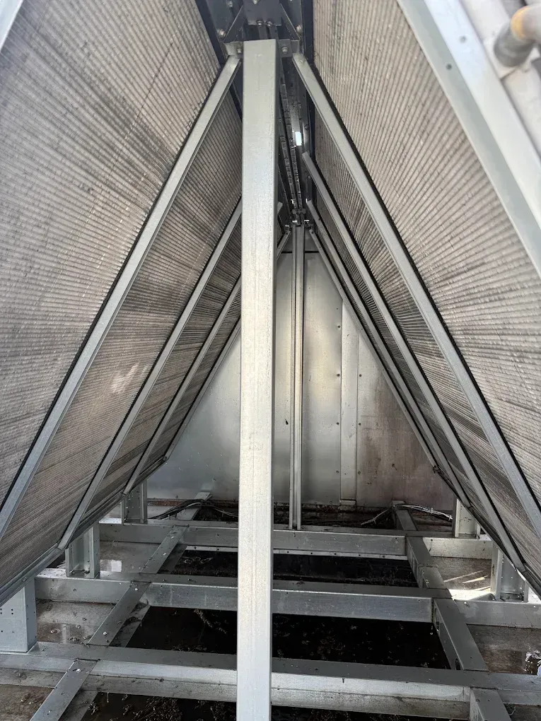 A metal stairway leading up into a narrow industrial structure with triangular support beams.