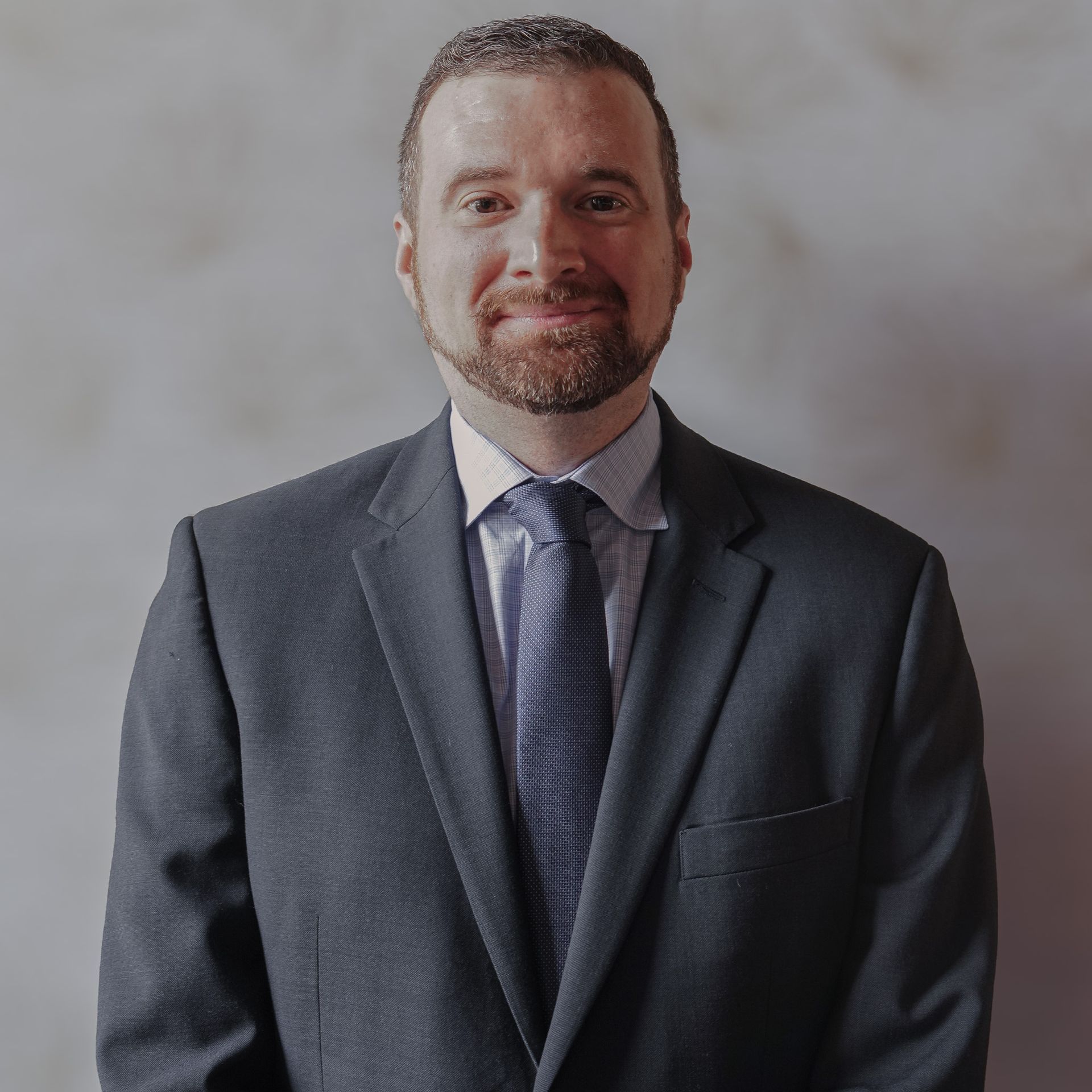 A man with a beard is wearing a suit and tie