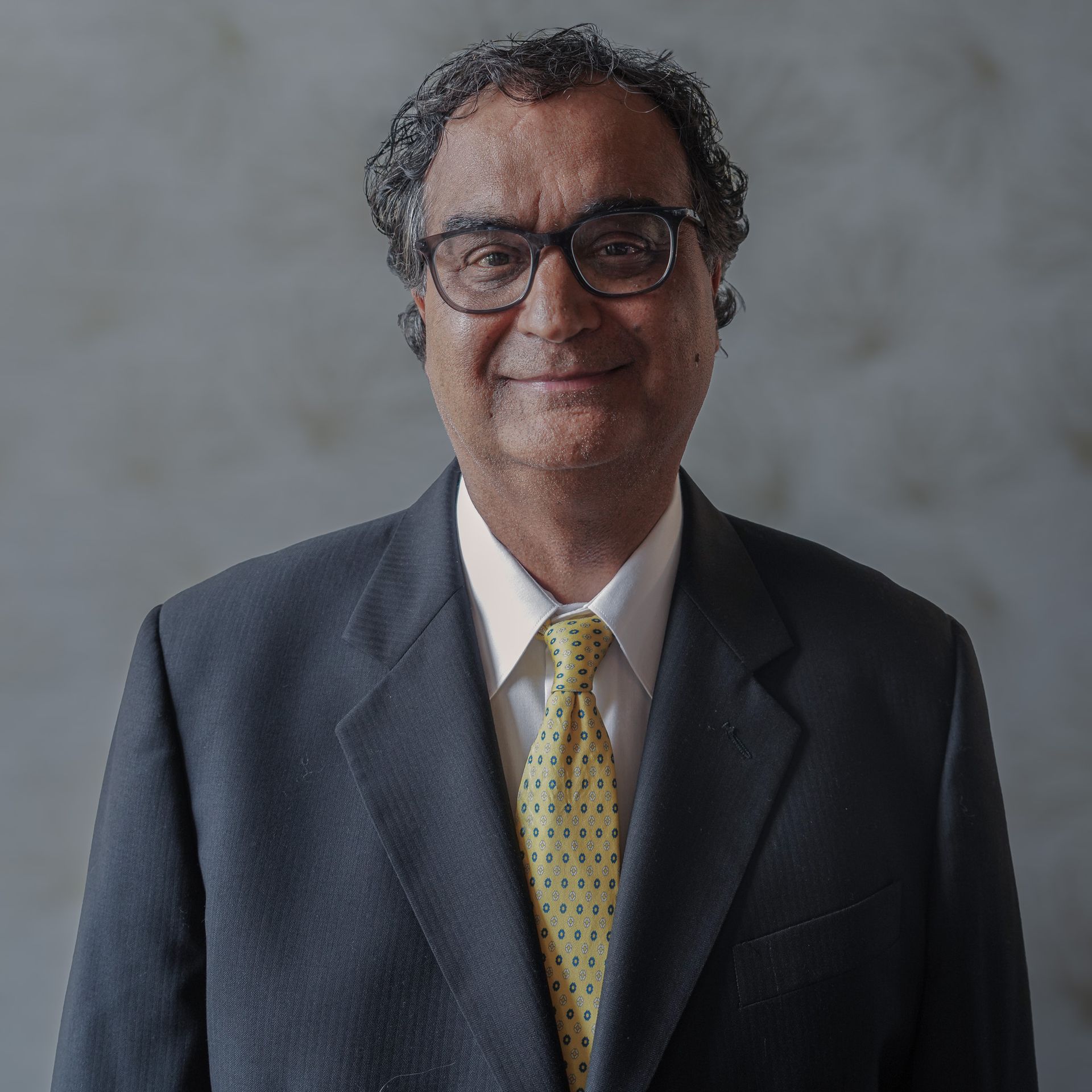 A man in a suit and tie is smiling for the camera