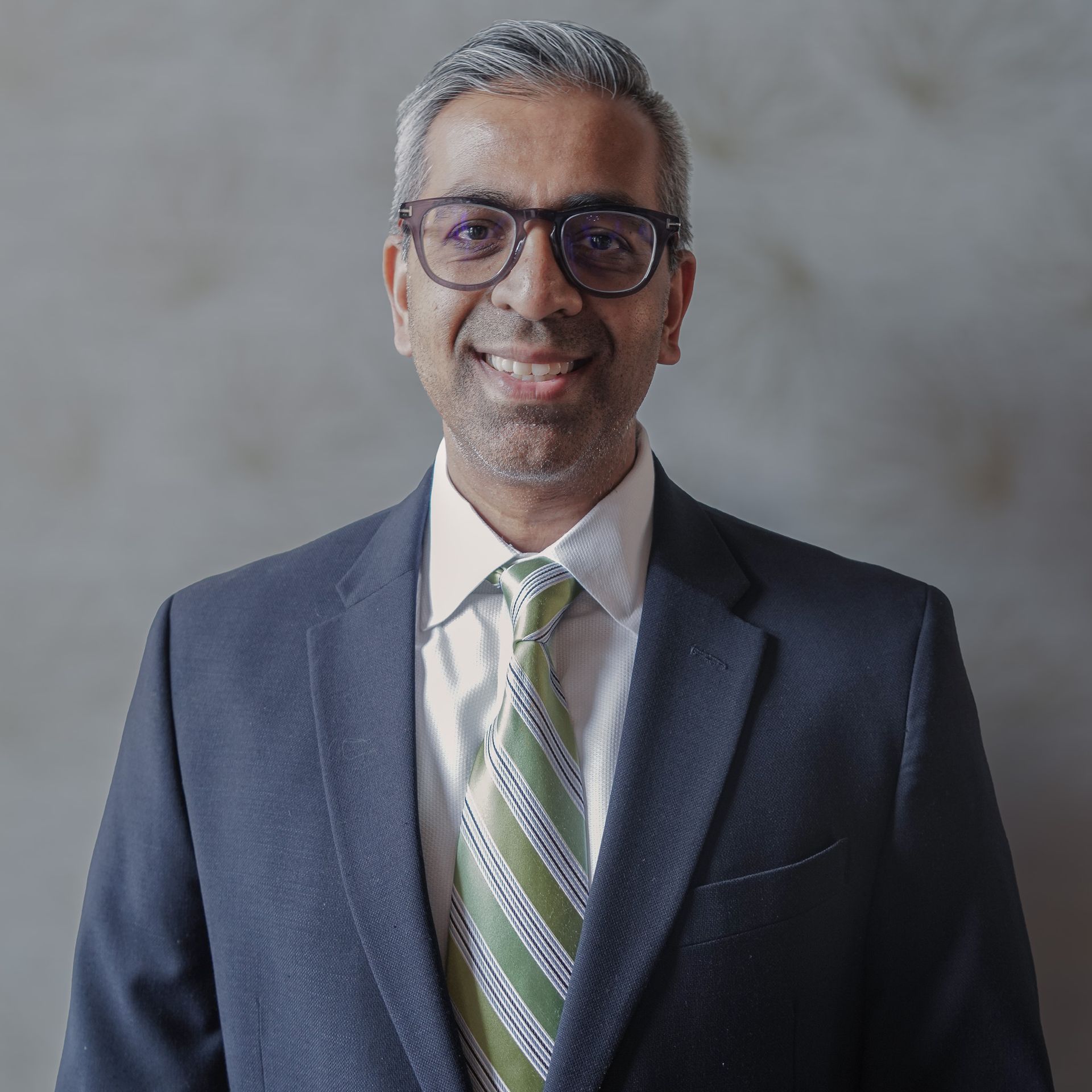 A man in a suit and tie is smiling for the camera.