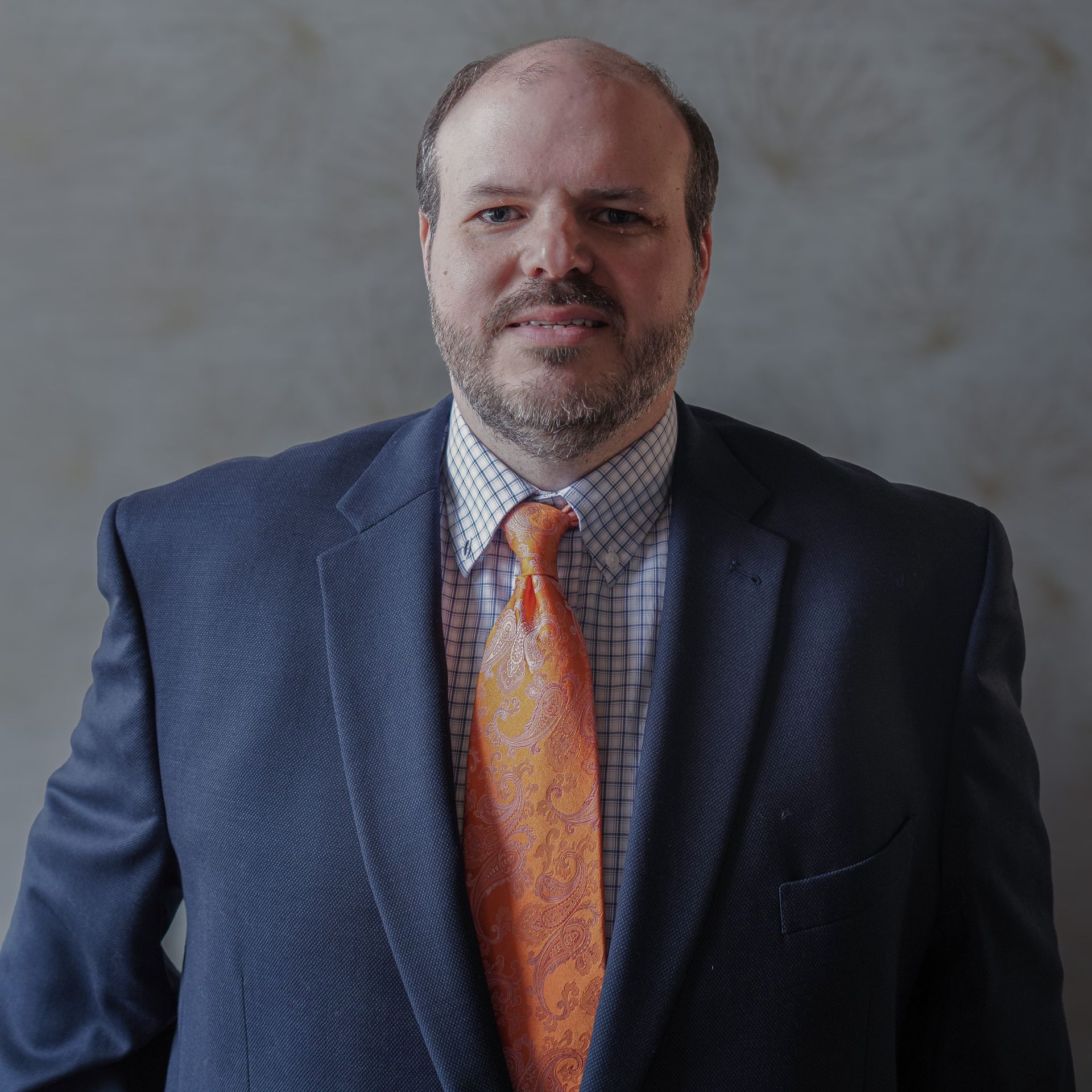 A man in a suit and tie is smiling for the camera