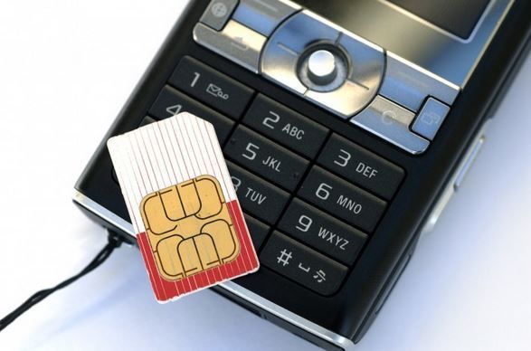 SIM card beside an open mobile phone keypad