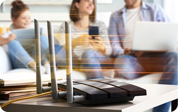 Wireless router on a desk with people blurred in the background, suggesting an office meeting