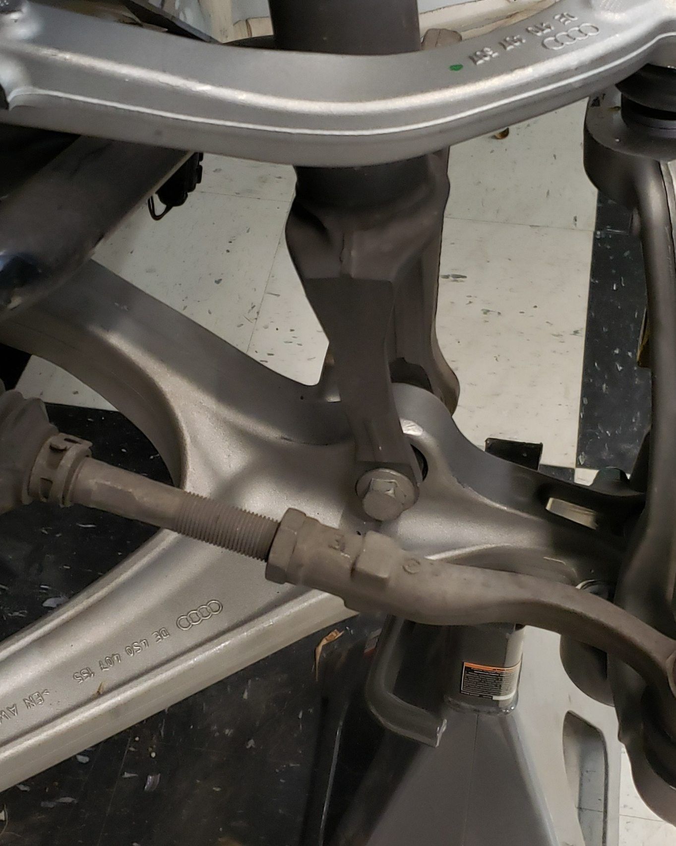 Close-up of a vehicle's suspension system, showing the control arm, shock absorber attachment, and axle assembly.