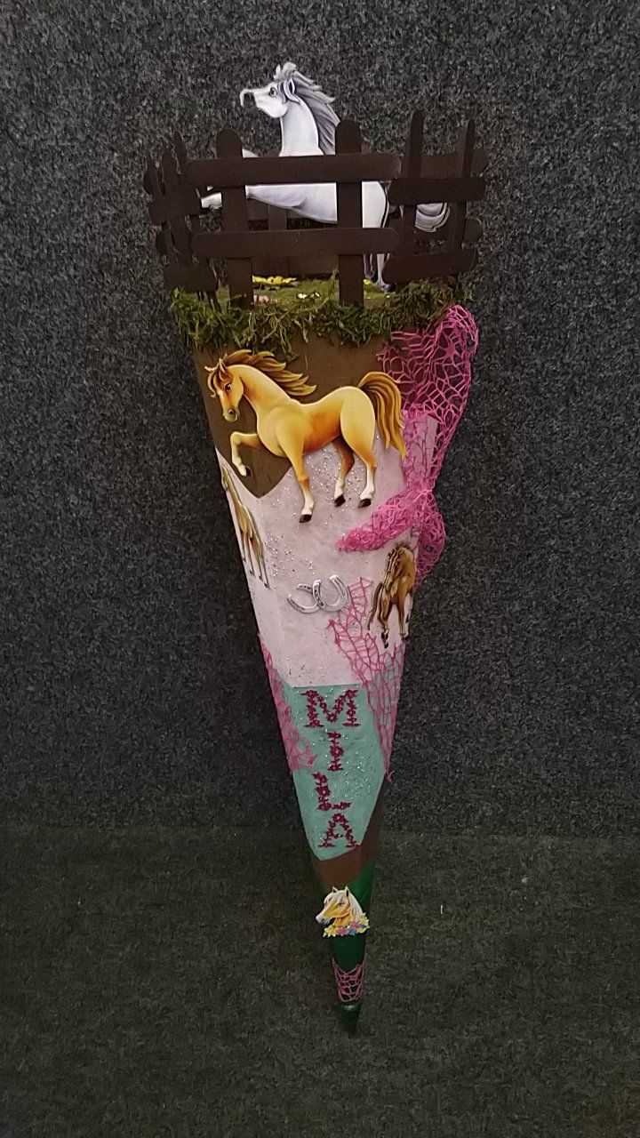 Ein Kegel mit Pferden und einem Zaun darauf.