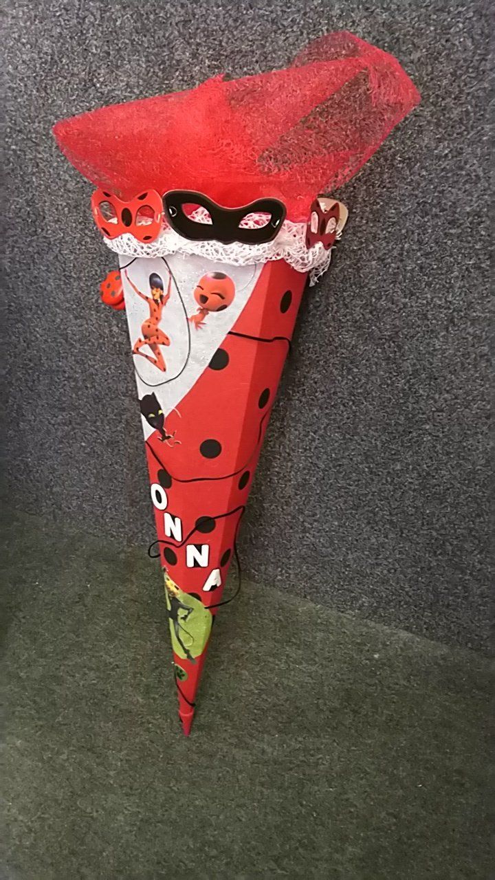 Auf einem Teppich steht ein roter Kegel mit einem Marienkäfer darauf.