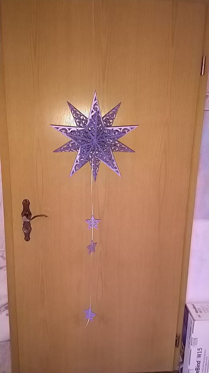 Eine Holztür, an der ein Stern hängt.