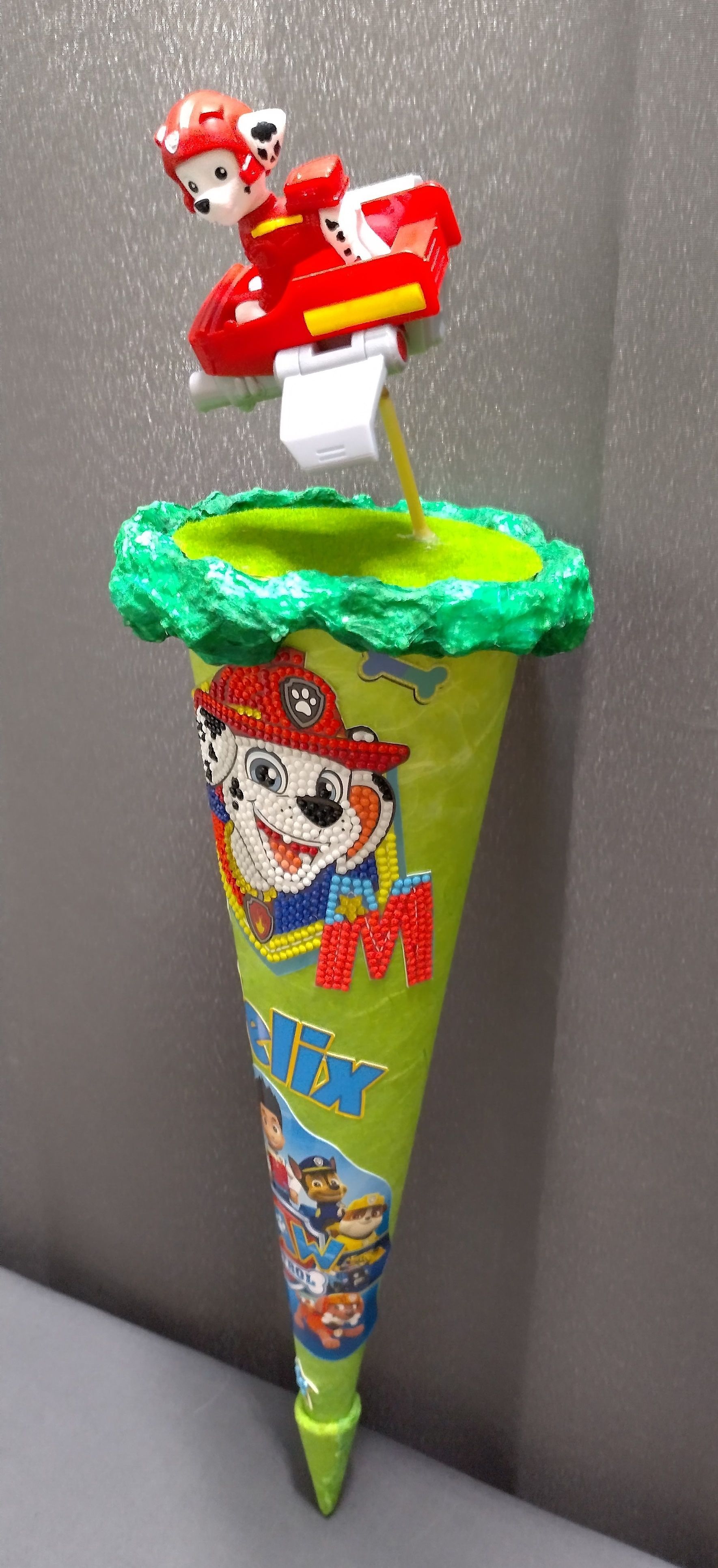 Ein grüner Kegel mit einem Spielzeug darauf.