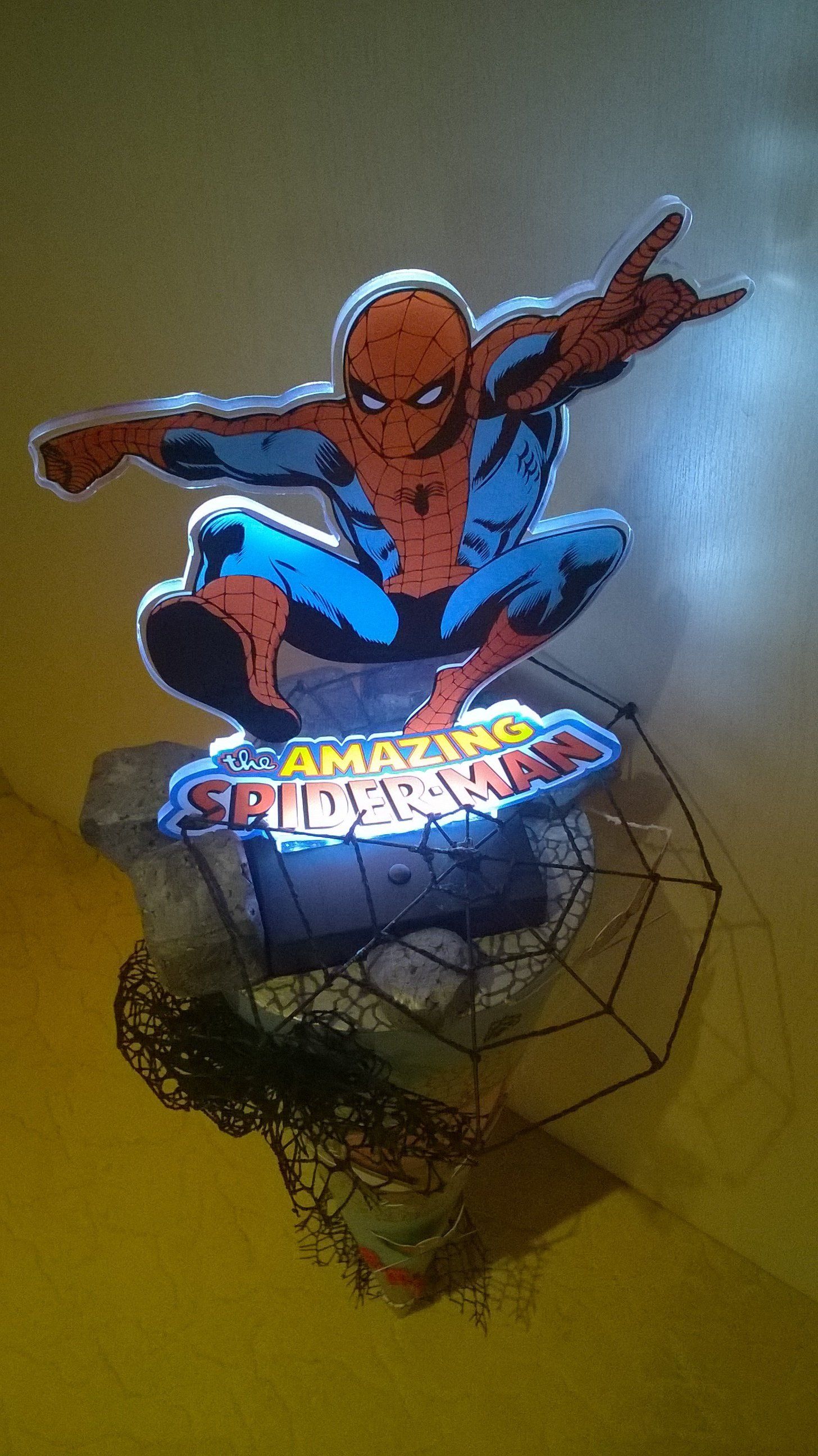 Eine Spiderman-Statue sitzt auf einem Spinnennetz.