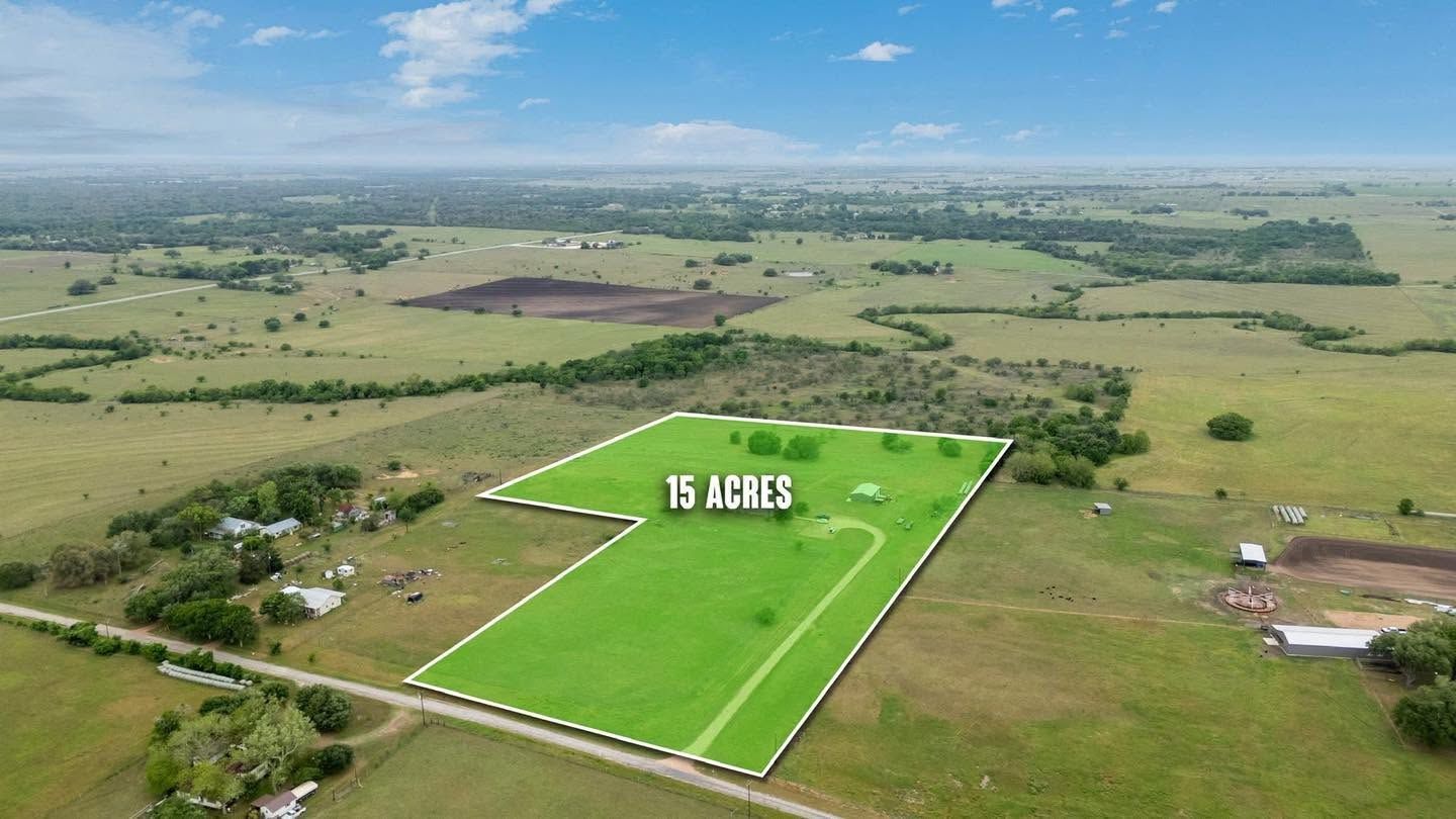 Aerial view of a green 15-acre plot outlined in white amid surrounding farmland.