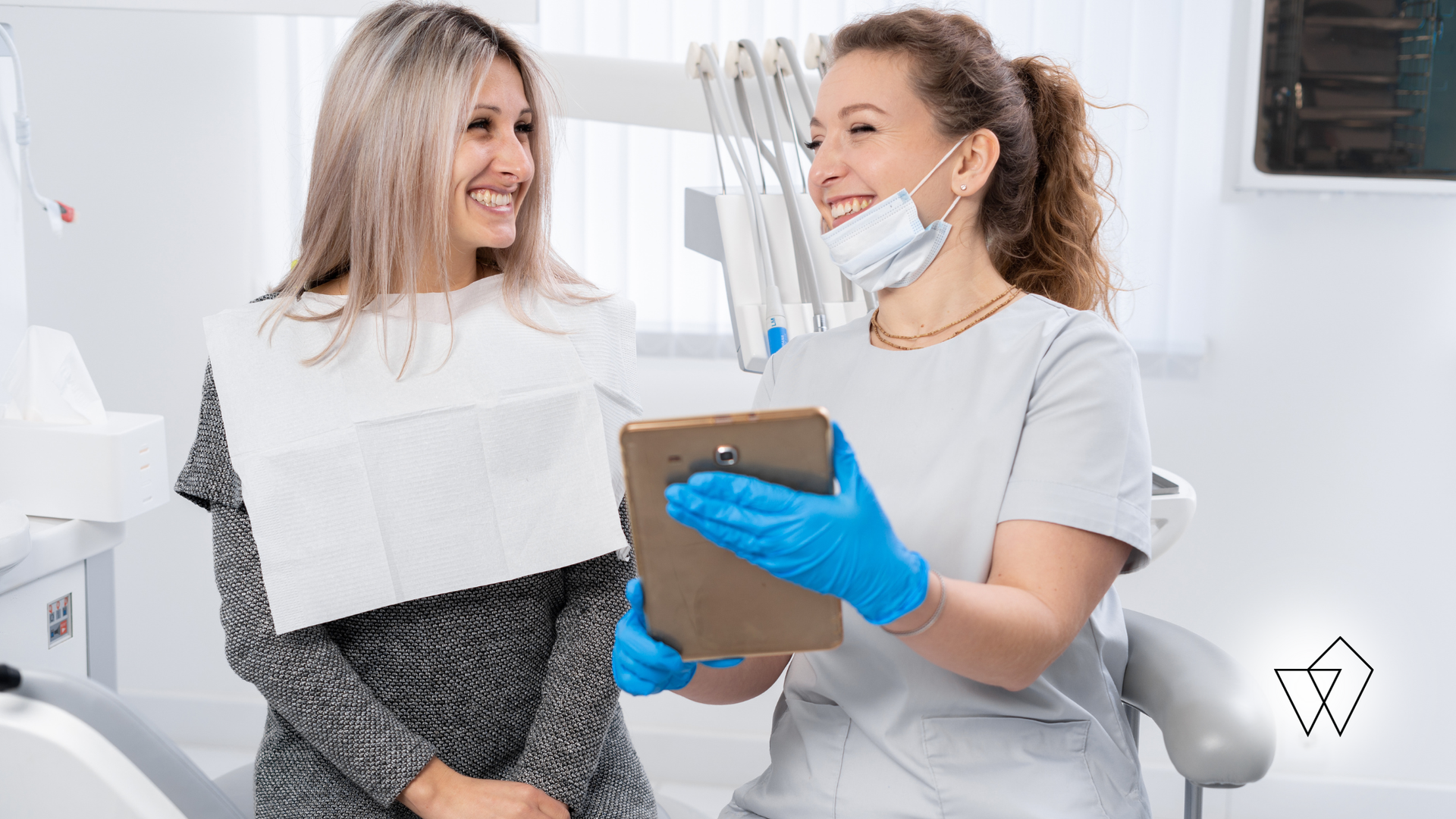Dentist and patient smiling during a dental consultation in a bright clinic, holding a clipboard and dental tools