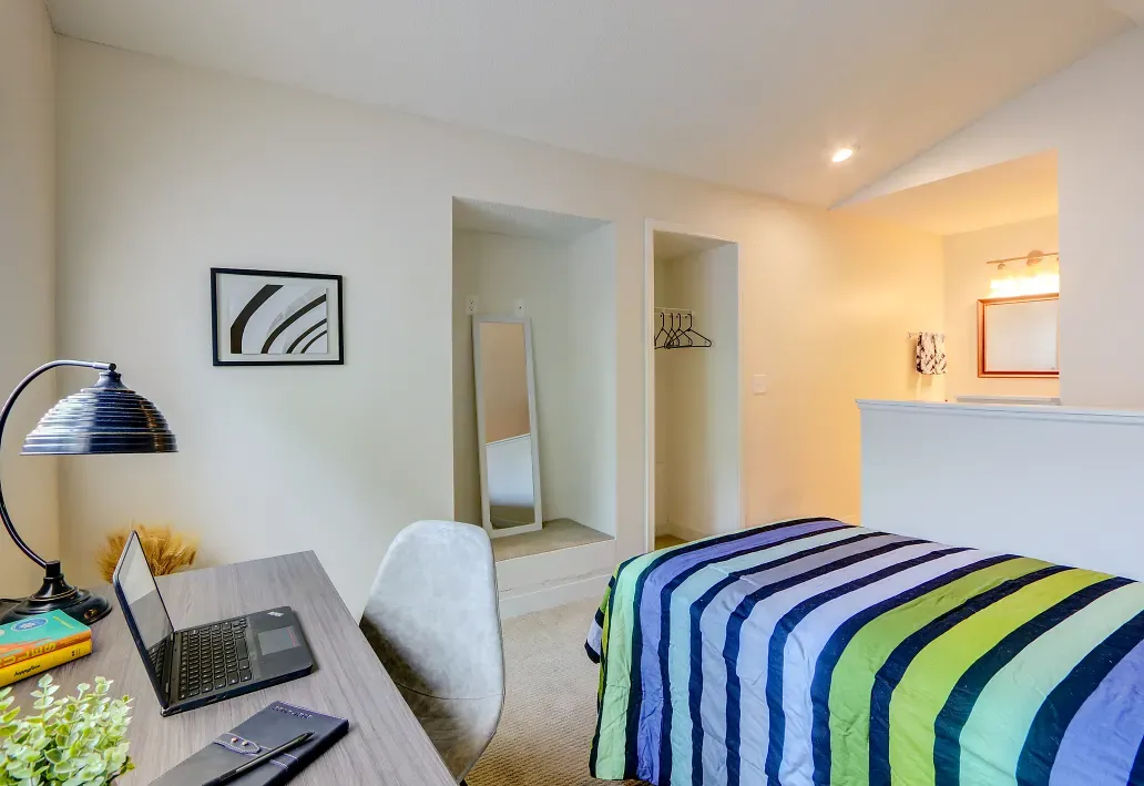 Interior of bedroom with view of bathroom doorway and closet