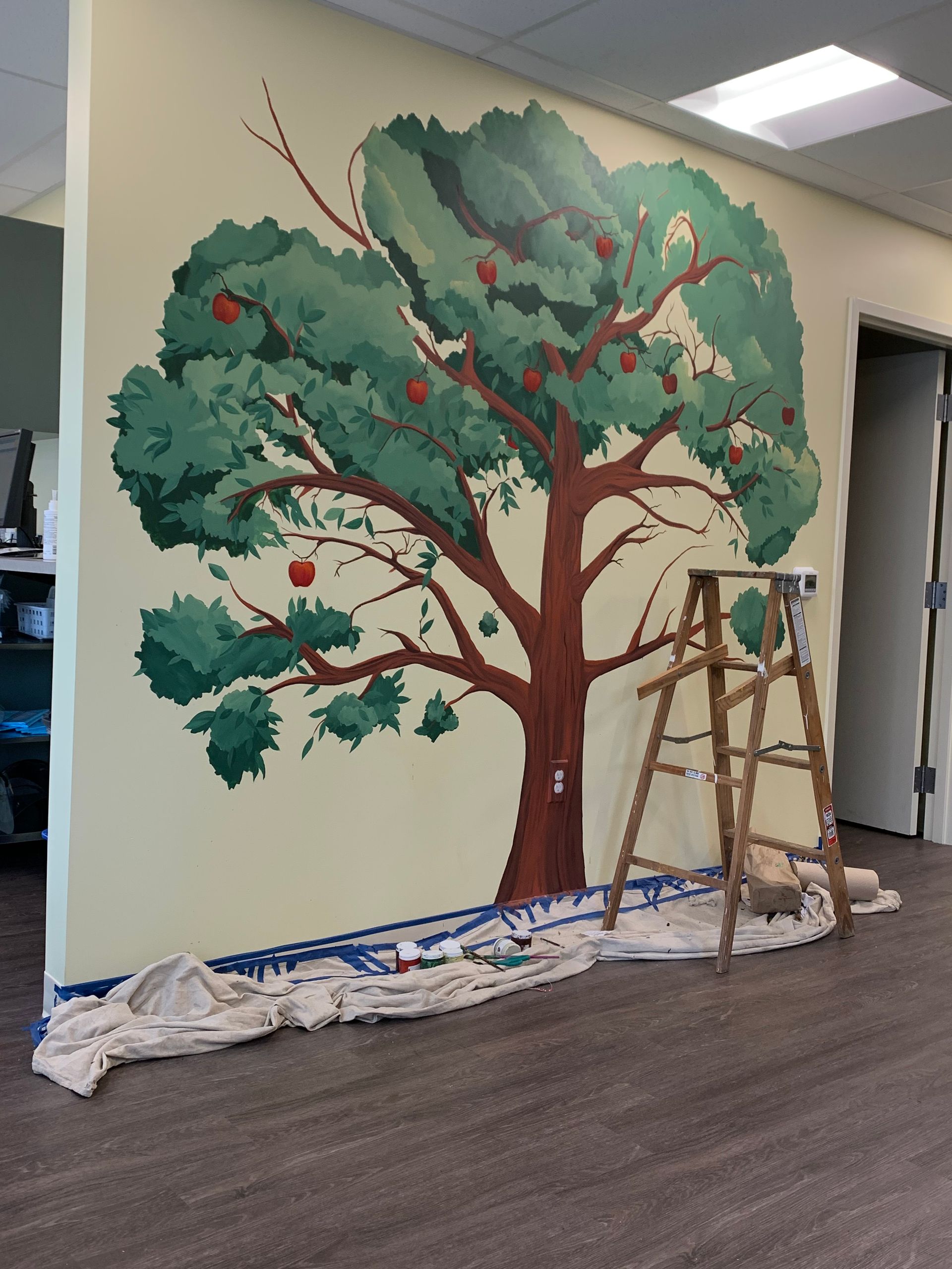 A painting of an apple tree on a wall at Advocare Fairmount Pediatrics