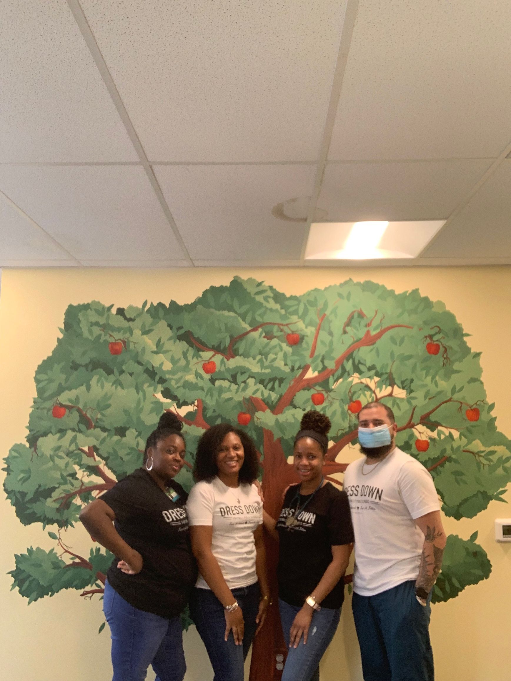Staff at Advocare Fairmount Pediatrics standing in front of a painting of a tree