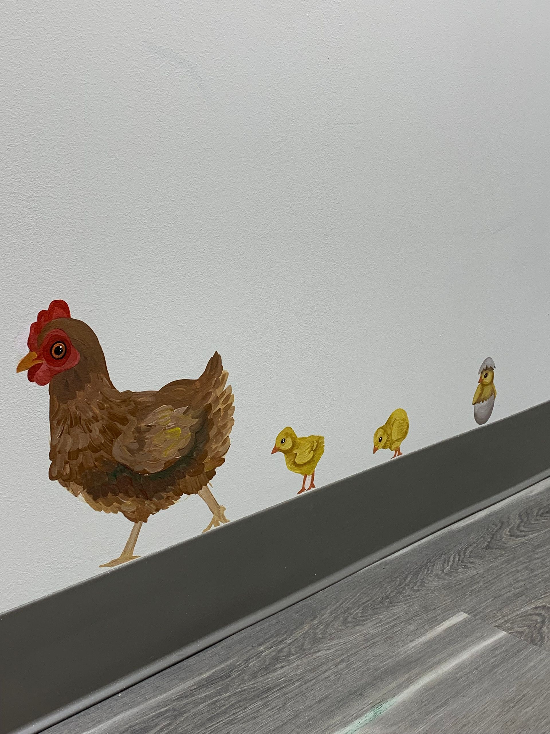 A painting of a chicken and two chicks on a wall at Advocare Fairmount Pediatrics