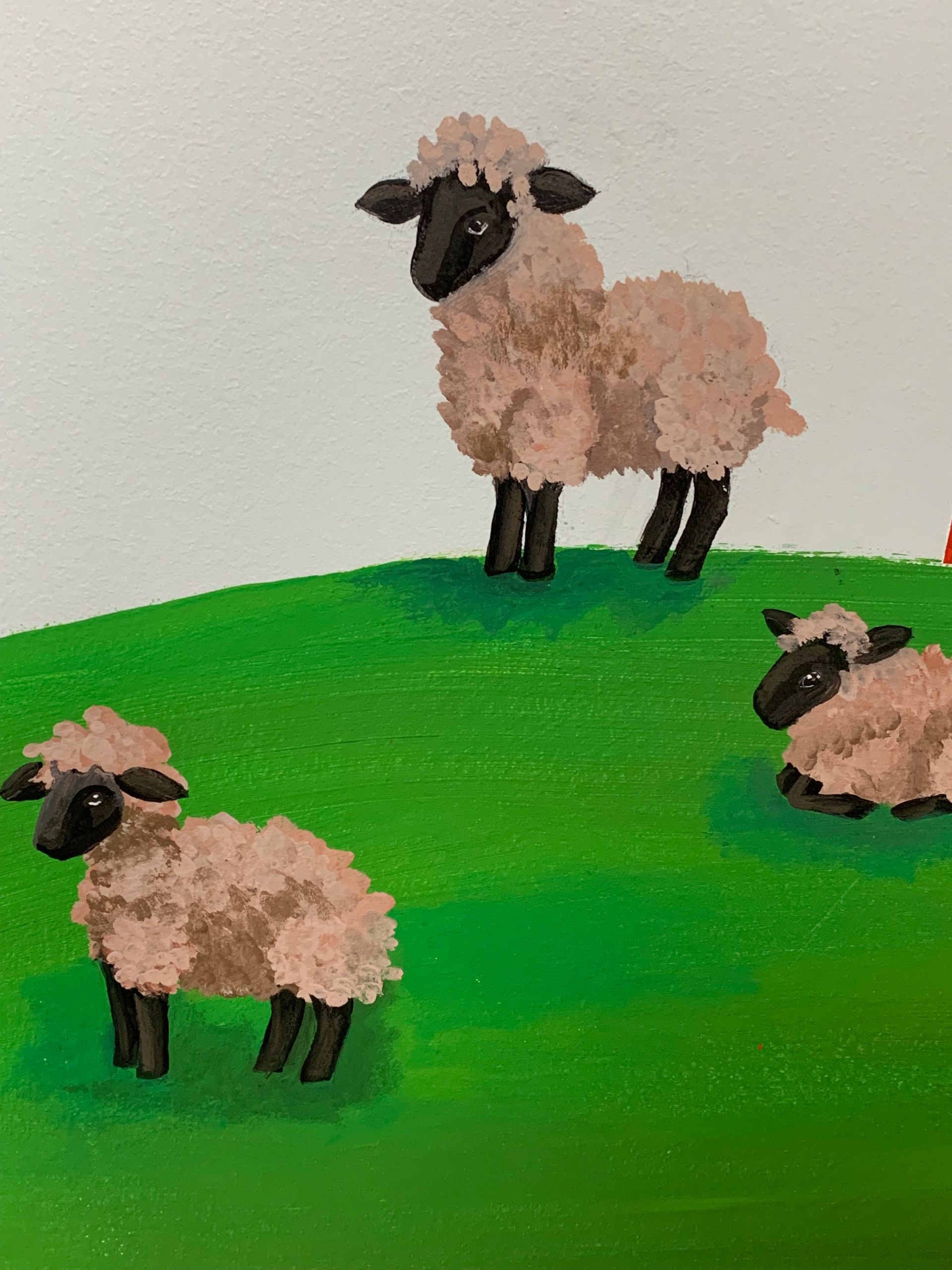 A painting of three sheep standing on top of a grassy hill at Advocare Fairmount Pediatrics