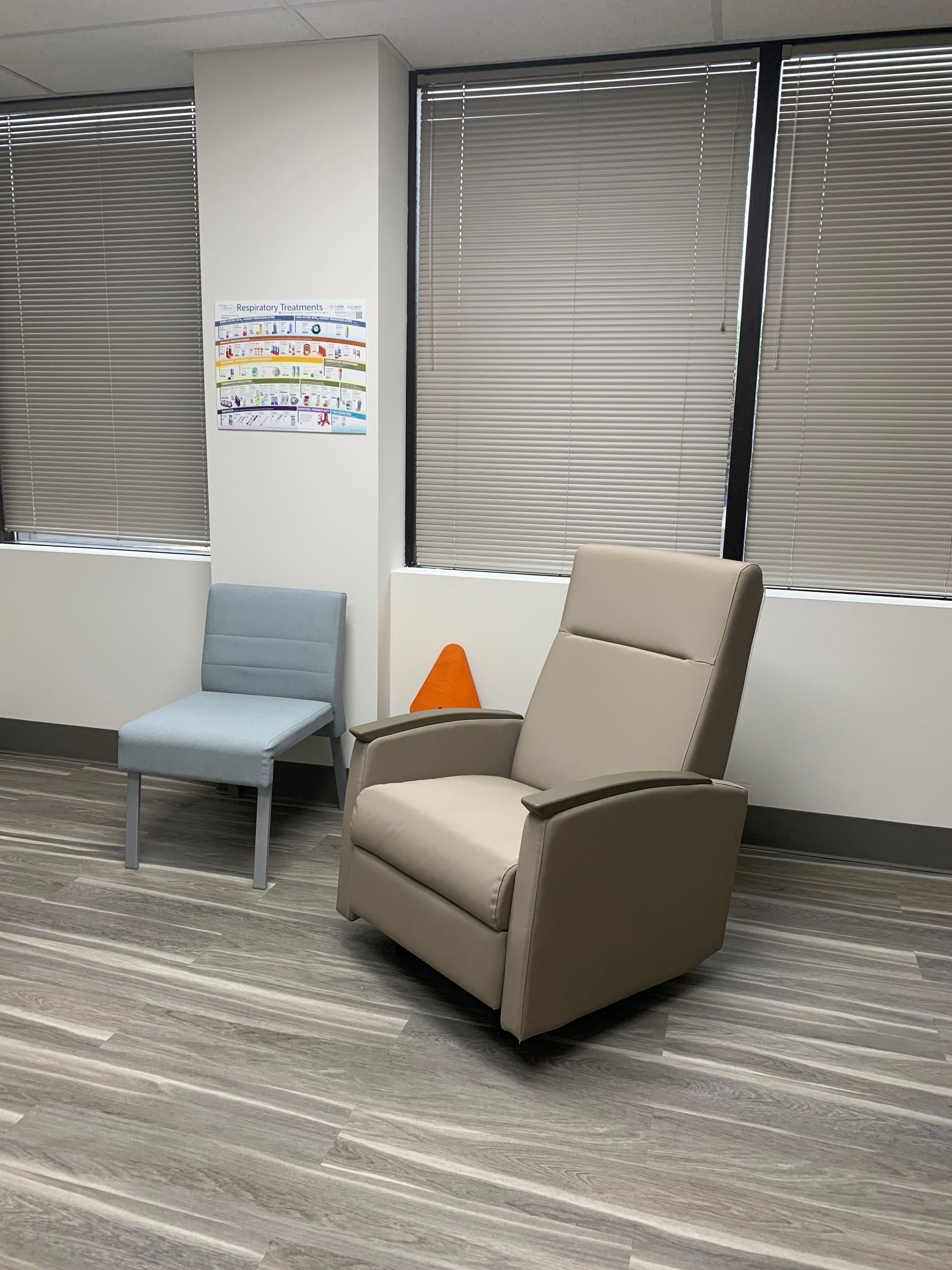 A chair is sitting in a room next to a window at at Advocare Fairmount Pediatrics