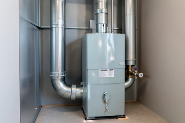 Industrial furnace with silver vent pipes in a utility room