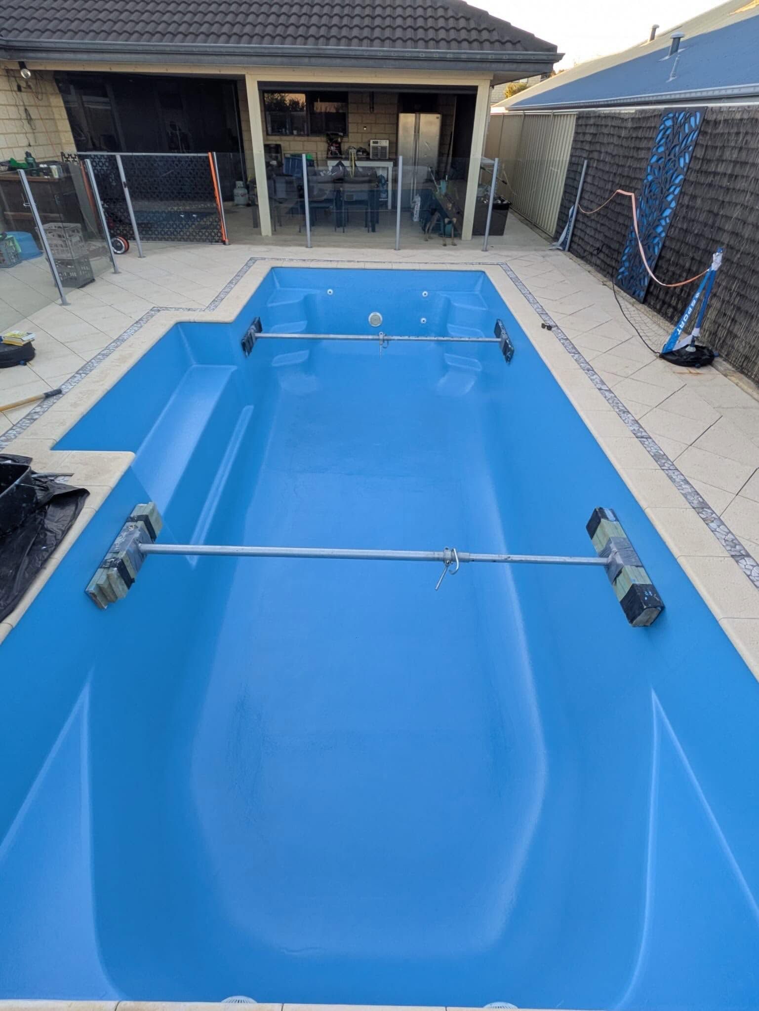 Round above-ground pool with clear blue water and a white rim outdoors