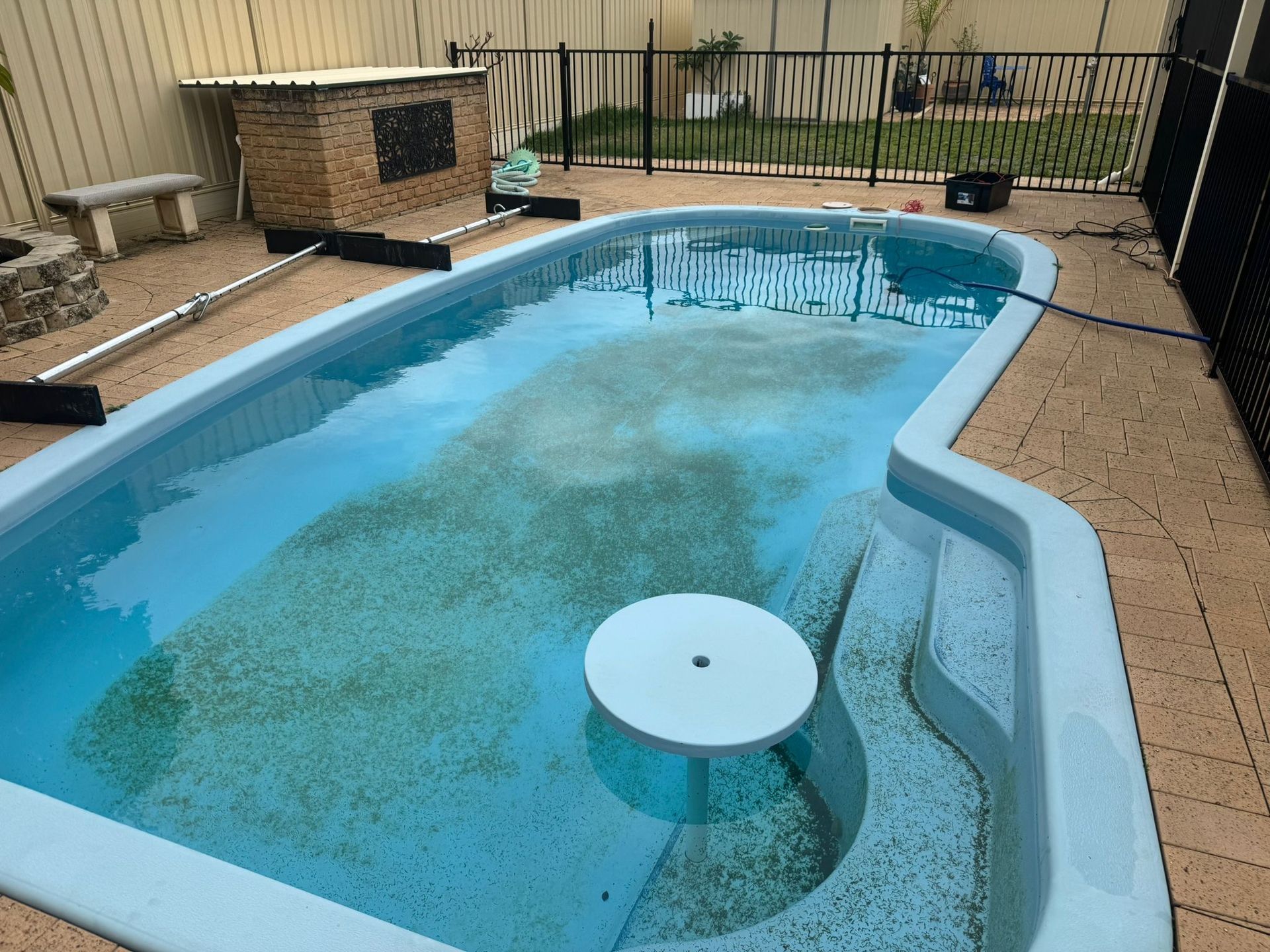 Before image of a swimming pool which requires resurfacing.