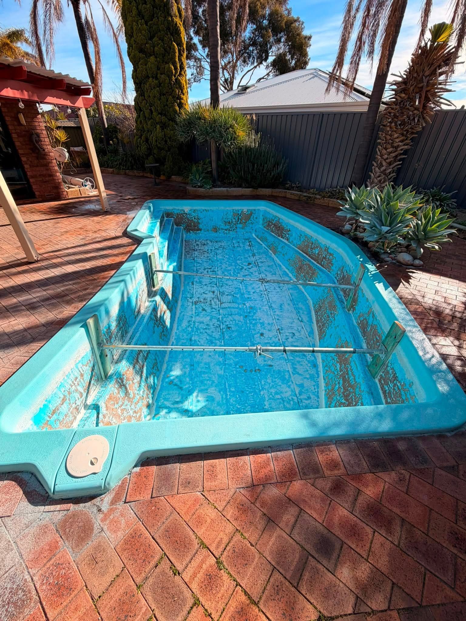 Before image of a swimming pool which requires resurfacing.