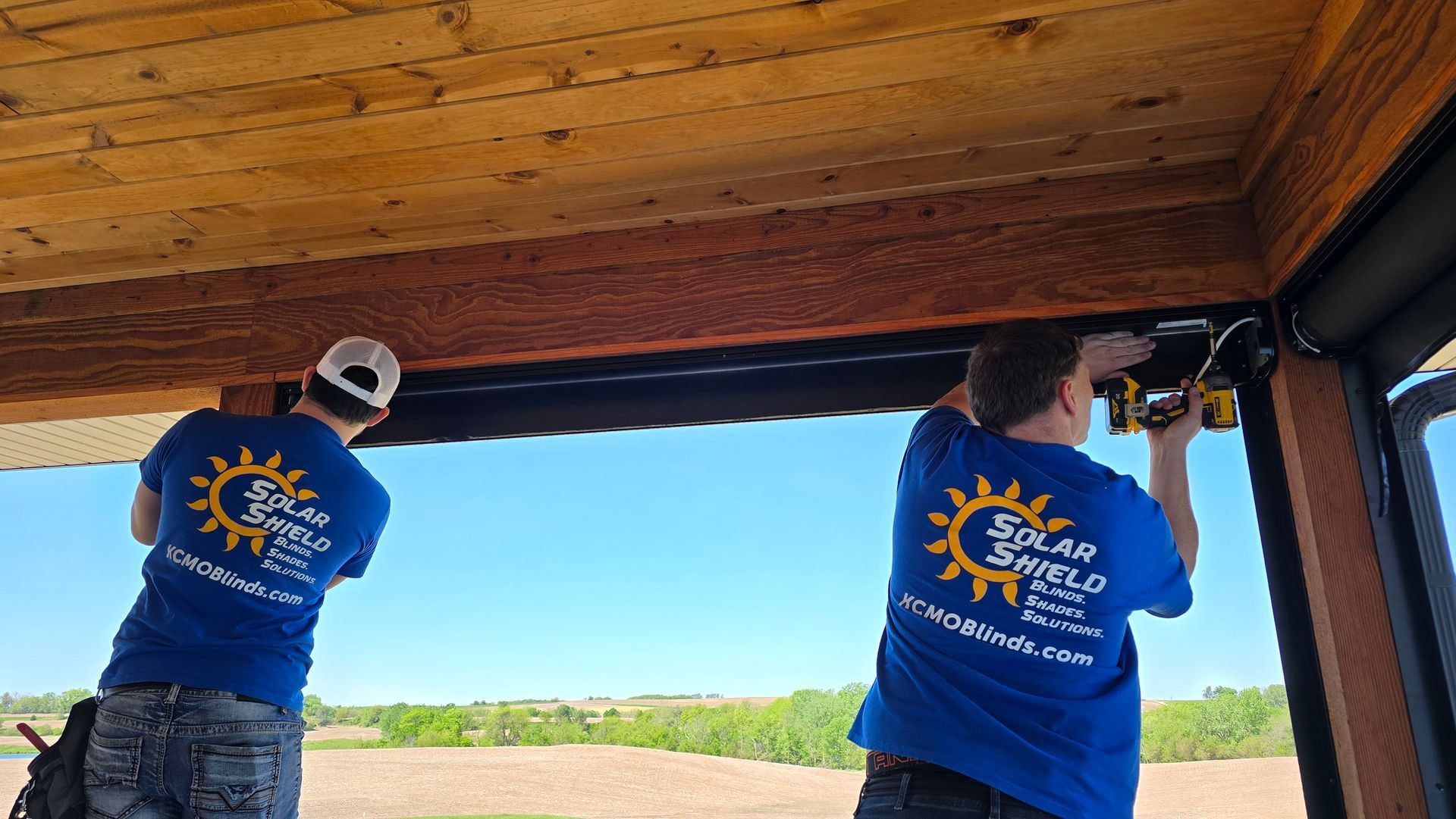 Solar Shield installers working on exterior patio shade
