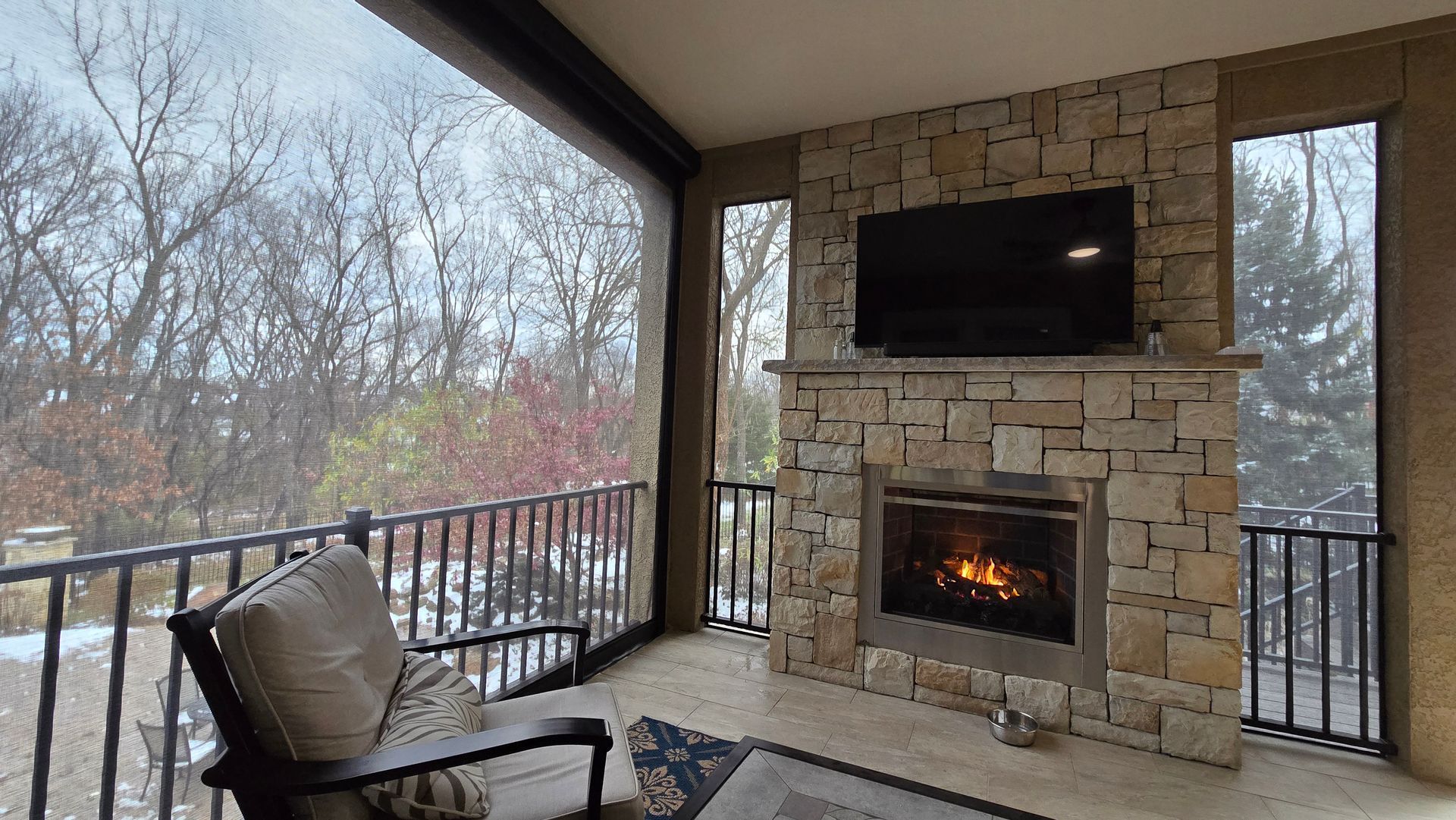 Patio in winter with fireplace on using Solar Shield Patio Shades to keep space warm