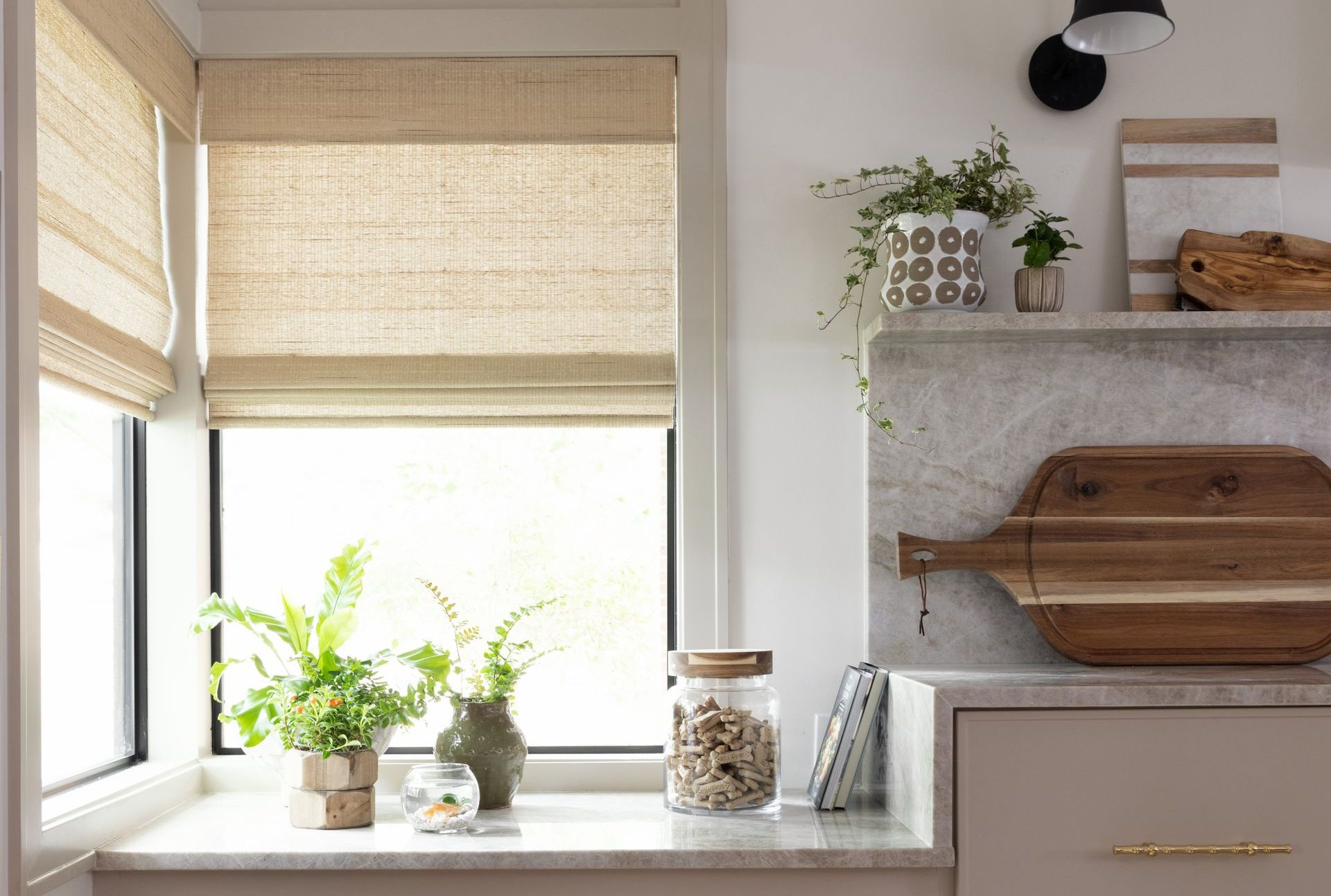 A kitchen with a window and a cutting board on the counter.