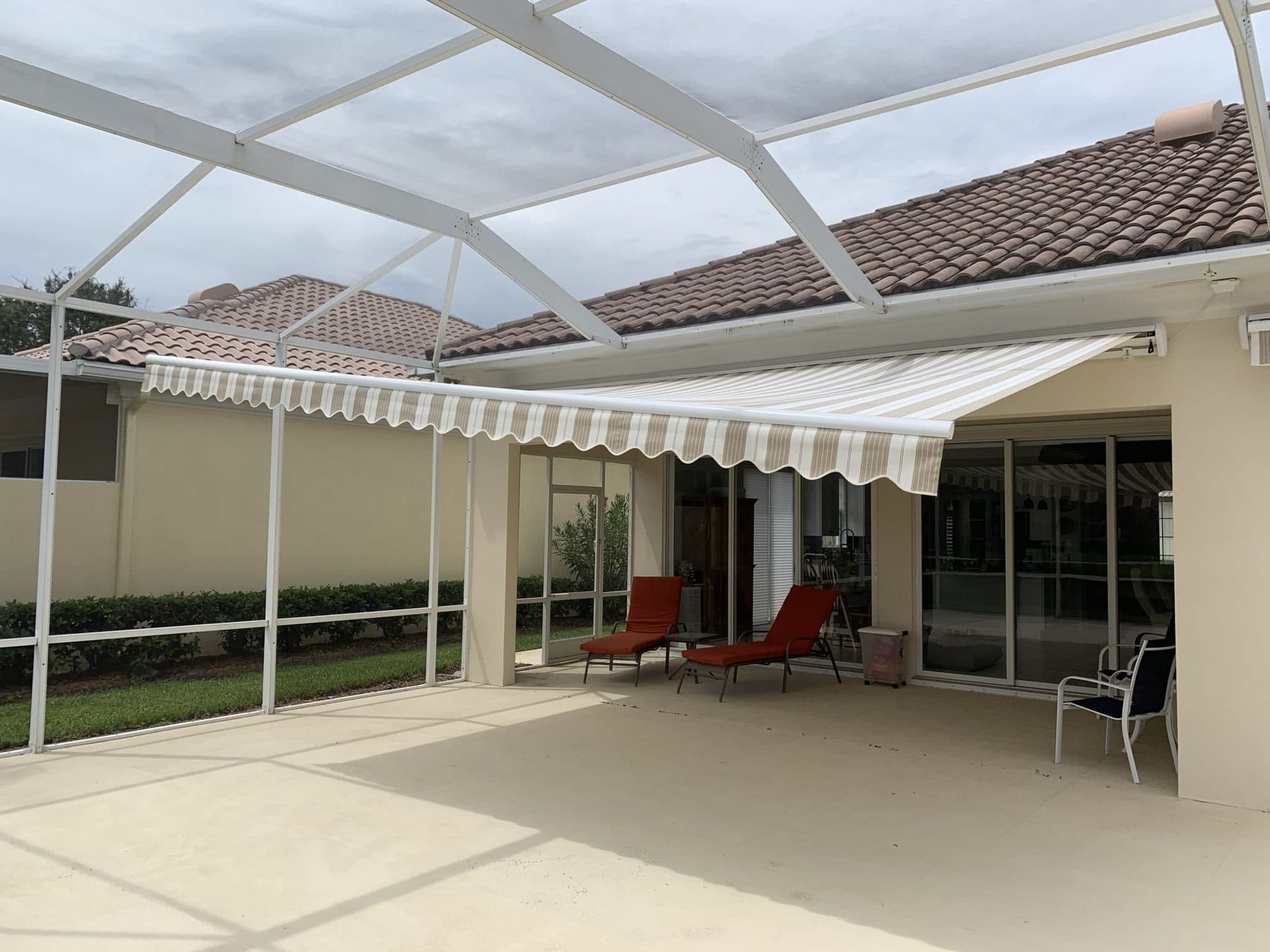 A patio with a white awning and chairs underneath it