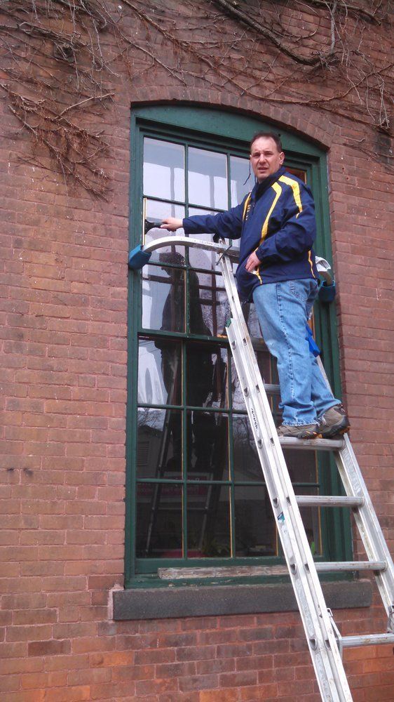 Owner Cleaning Windows On Ladder — Hadley, MA — Family Window Cleaning & Property Maintenance