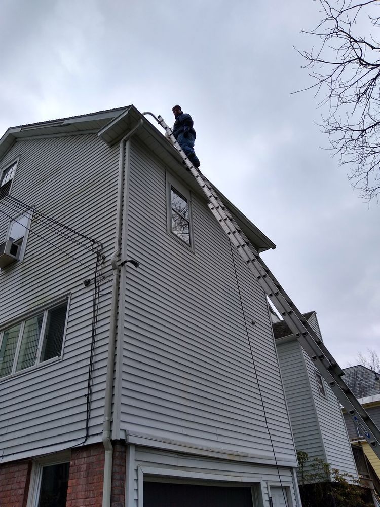 Person On Ladder Roof Top — Hadley, MA — Family Window Cleaning & Property Maintenance