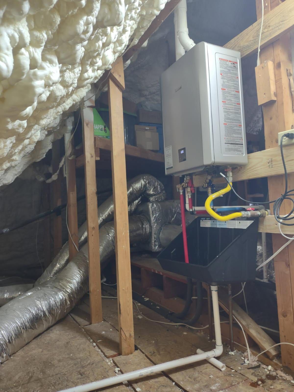 A gas water heater installed in an attic surrounded by insulation, ductwork, and wooden supports.