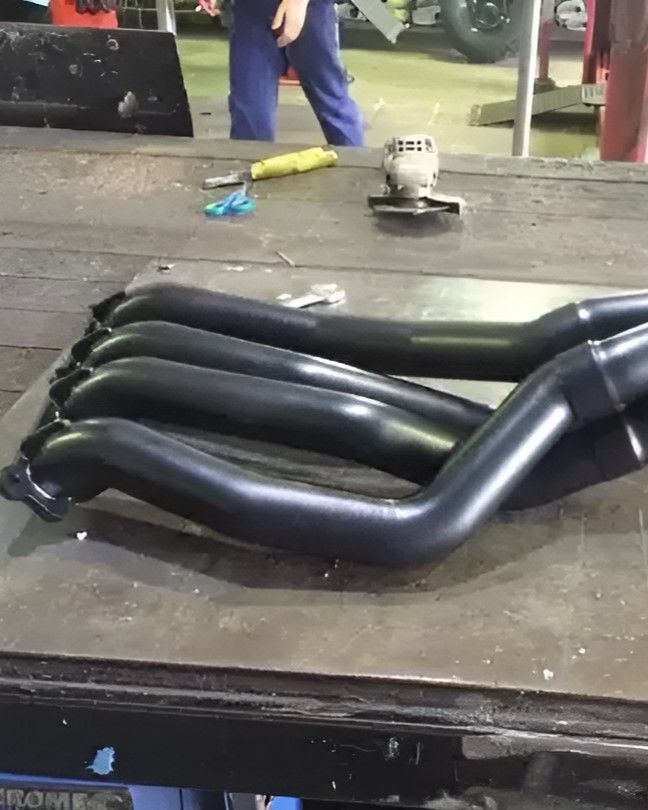 A Bunch of Exhaust Pipes Are Laying on a Table — Ace Exhaust Centre in Berserker, QLD