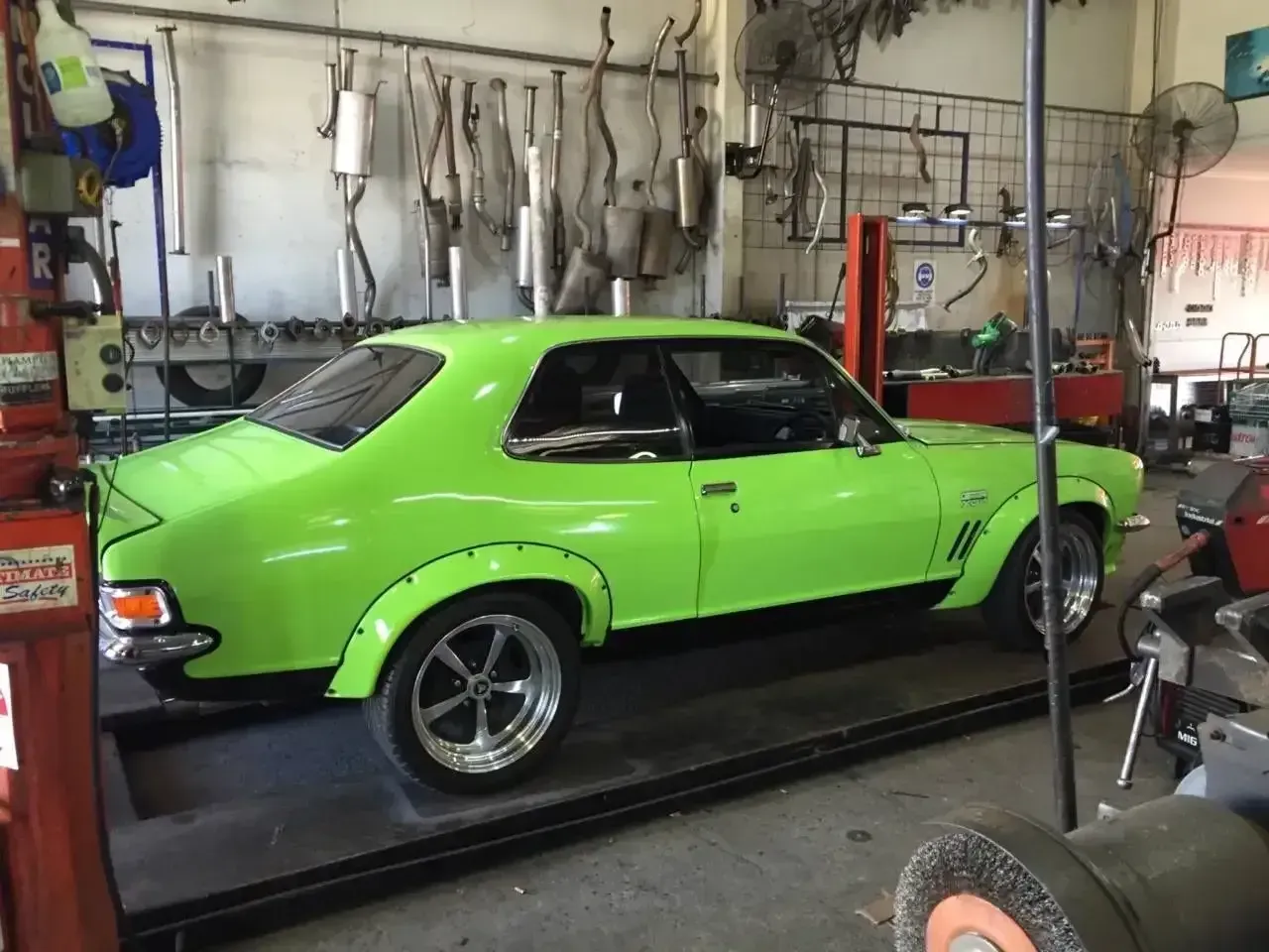 A Green Car is Parked on a Ramp in a Garage — Ace Exhaust Centre in Berserker, QLD