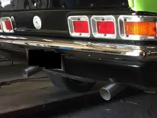 A Black Car With a License Plate That is Missing is Parked in a Garage — Ace Exhaust Centre in Berserker, QLD