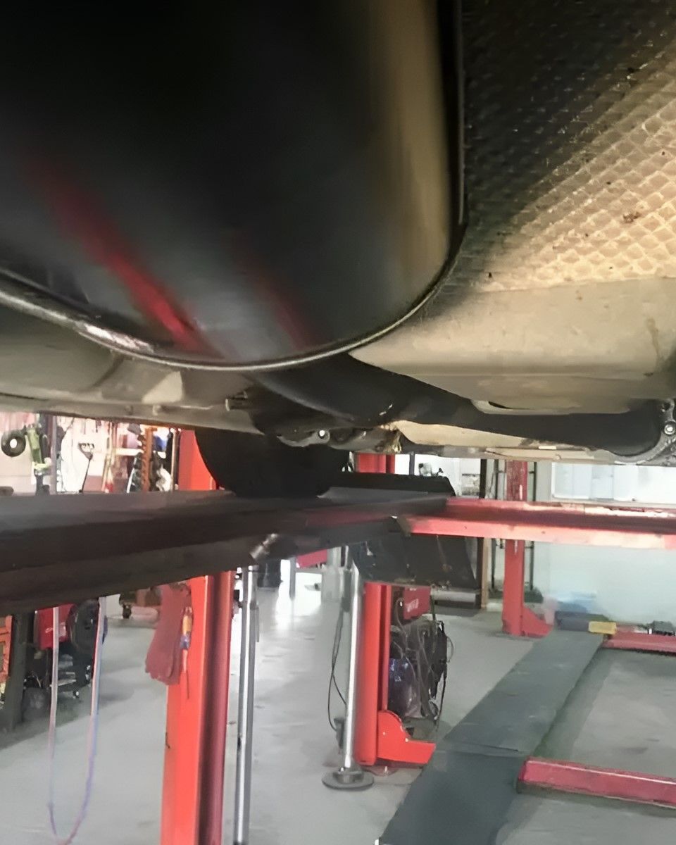 A Car is Sitting on a Lift in a Garage — Ace Exhaust Centre in Berserker, QLD