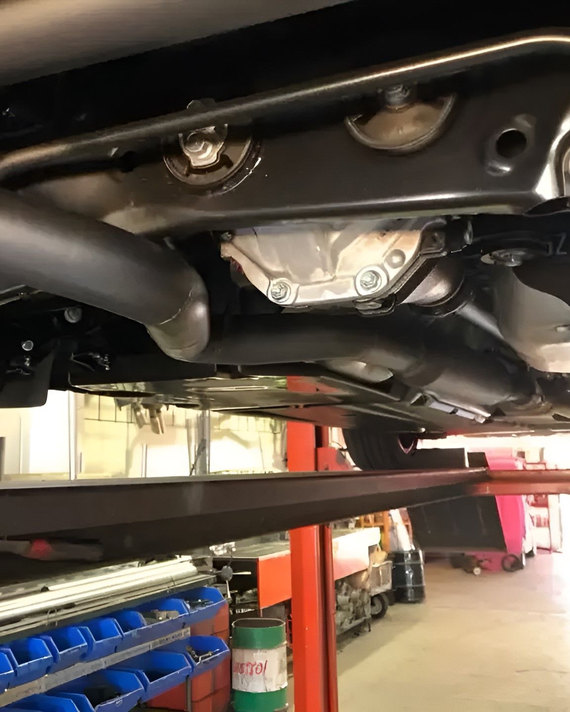 A Car is Sitting on a Lift in a Garage — Ace Exhaust Centre in Berserker, QLD