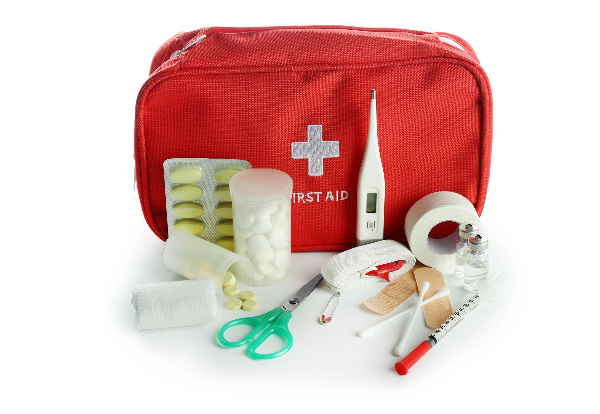 Botiquín de primeros auxilios rojo con suministros médicos, que incluye vendas, tijeras, termómetro y pastillas.