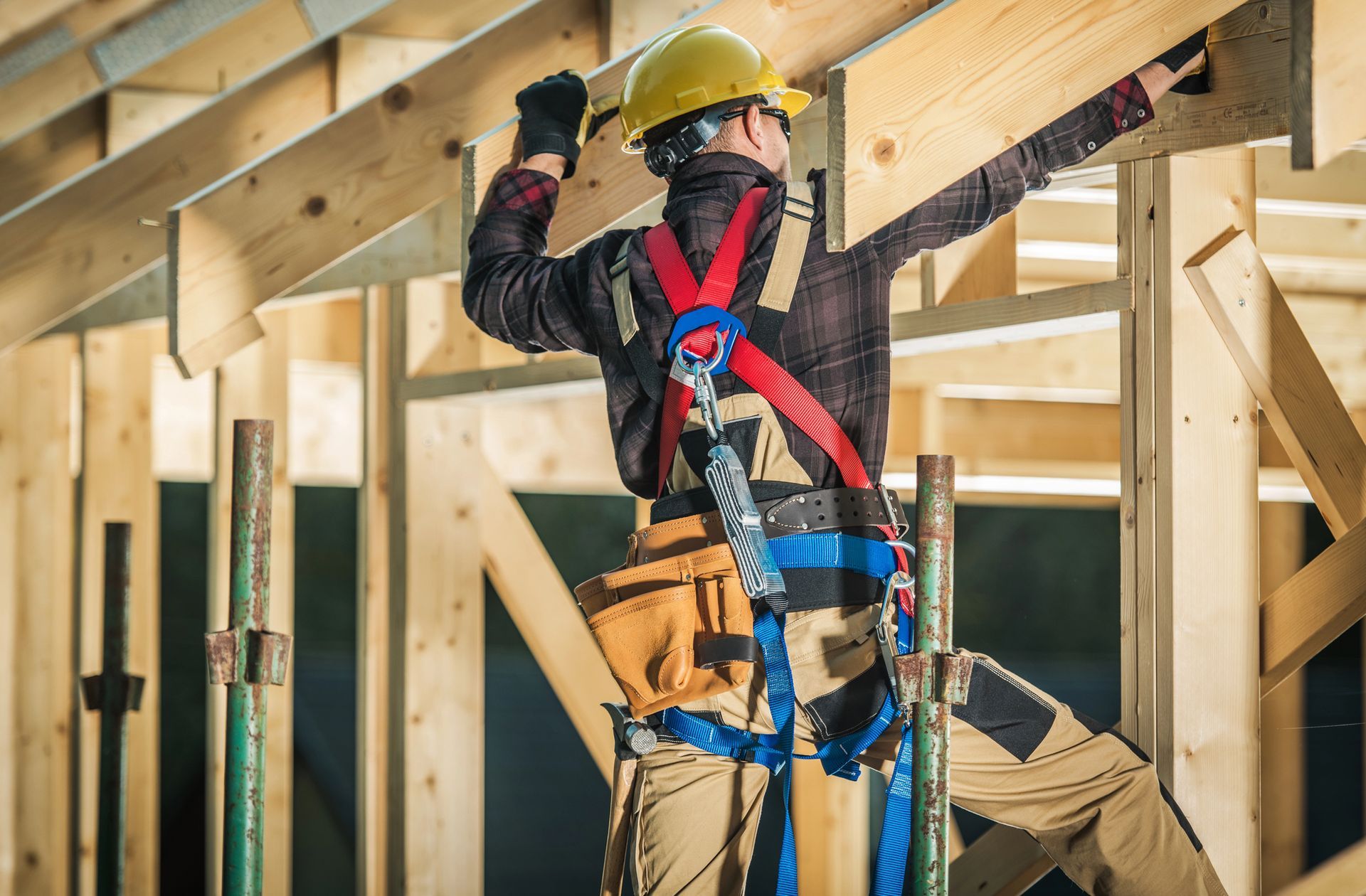 Obrero de la construcción con equipo de seguridad, trabajando en una estructura de madera.