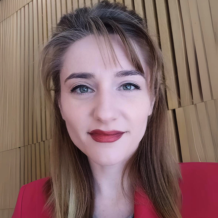 Close-up portrait of a person with red lipstick and blue eyes against a wooden backdrop