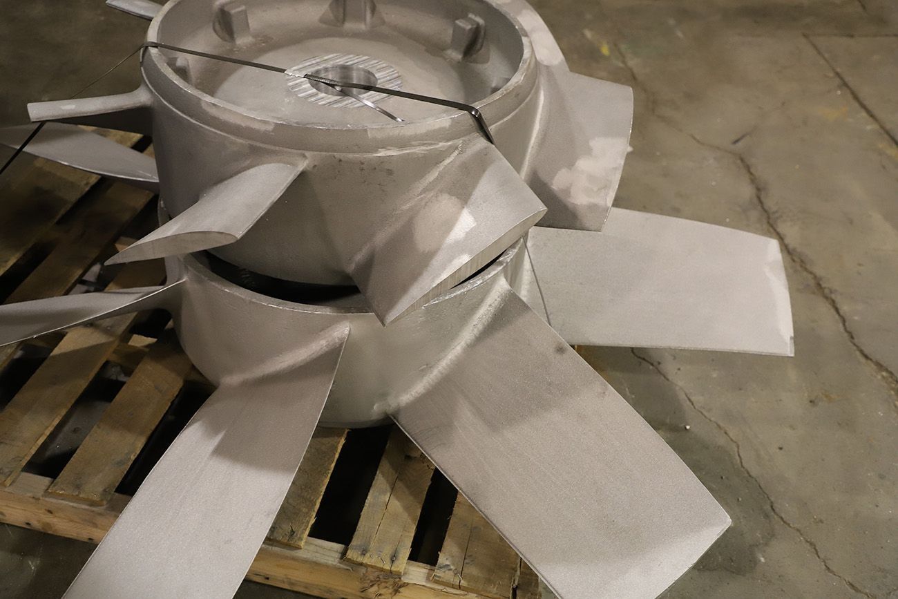 Wrapped metal container on a wooden pallet with white protective foam sheets in an industrial setting
