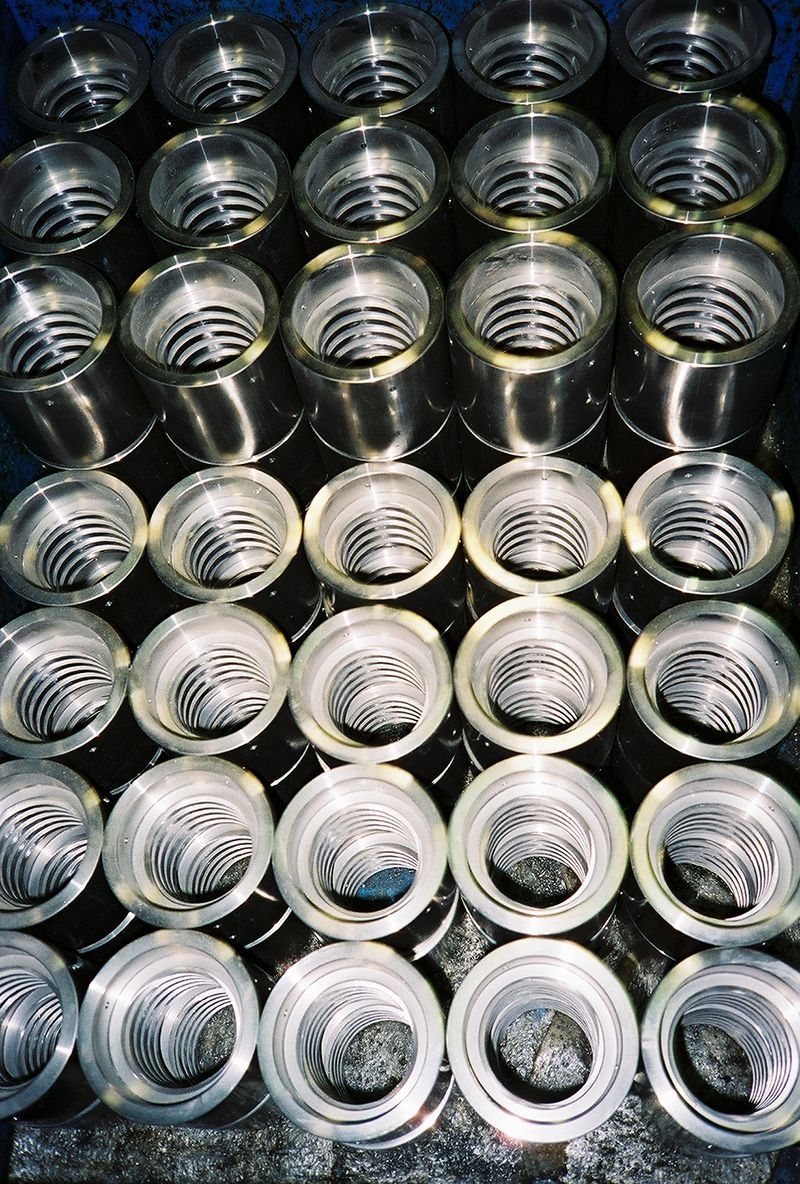 Rows of shiny metal can lids stacked together, viewed from above.