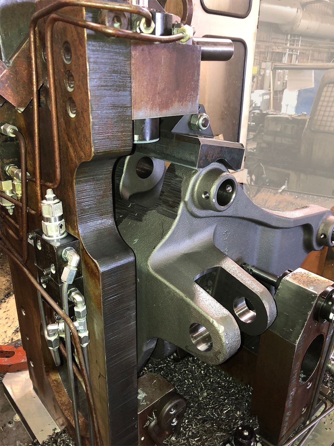 Close-up of a vintage metal machine mechanism with gears and bolts inside a workshop.