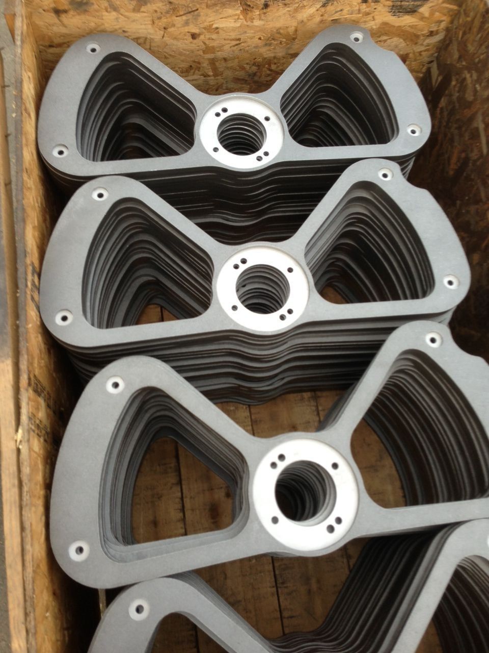 Stacked black metal fan grilles with silver centers on a wooden surface