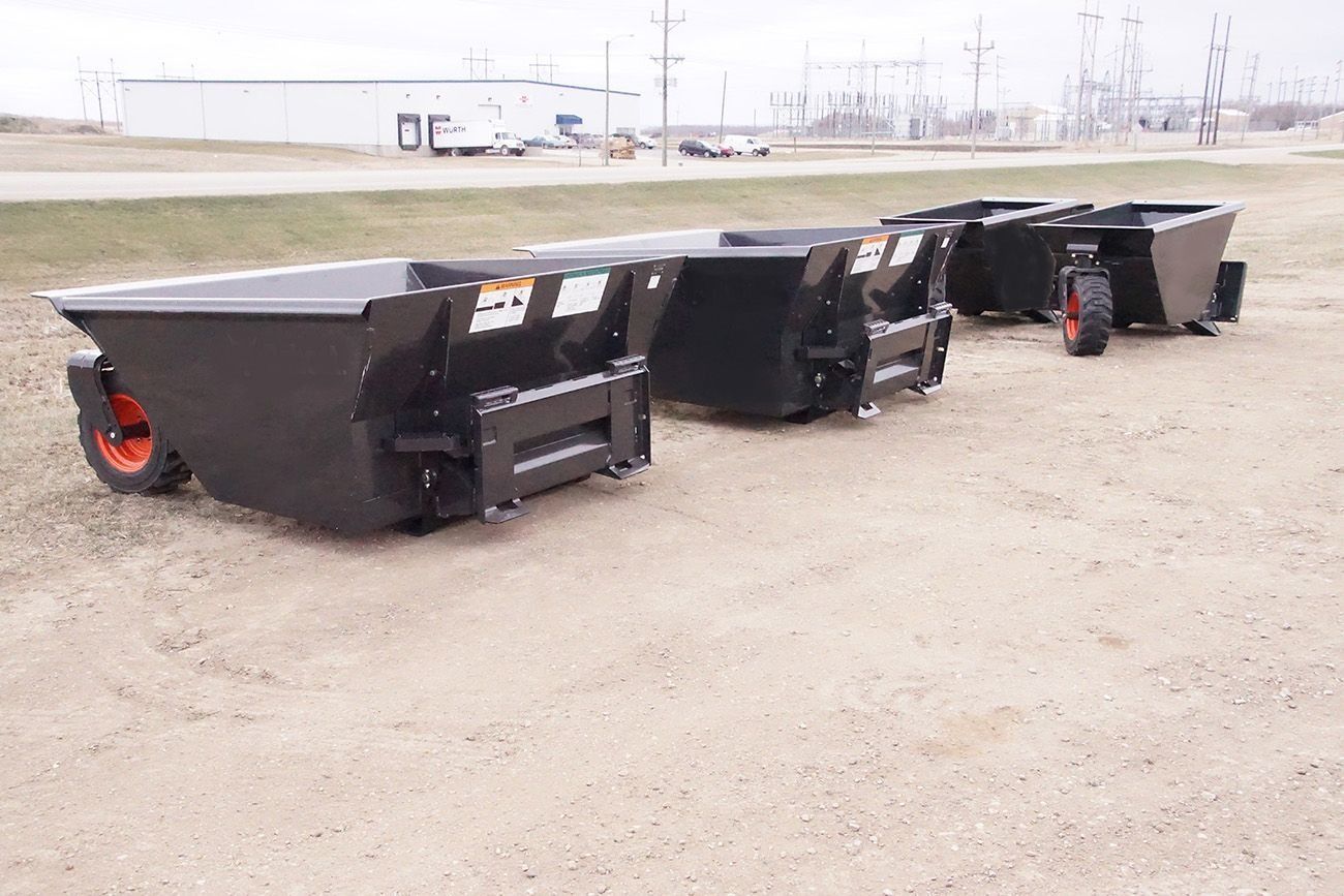 Large black industrial trailer chassis with wheels and metal frames parked on a gravel lot