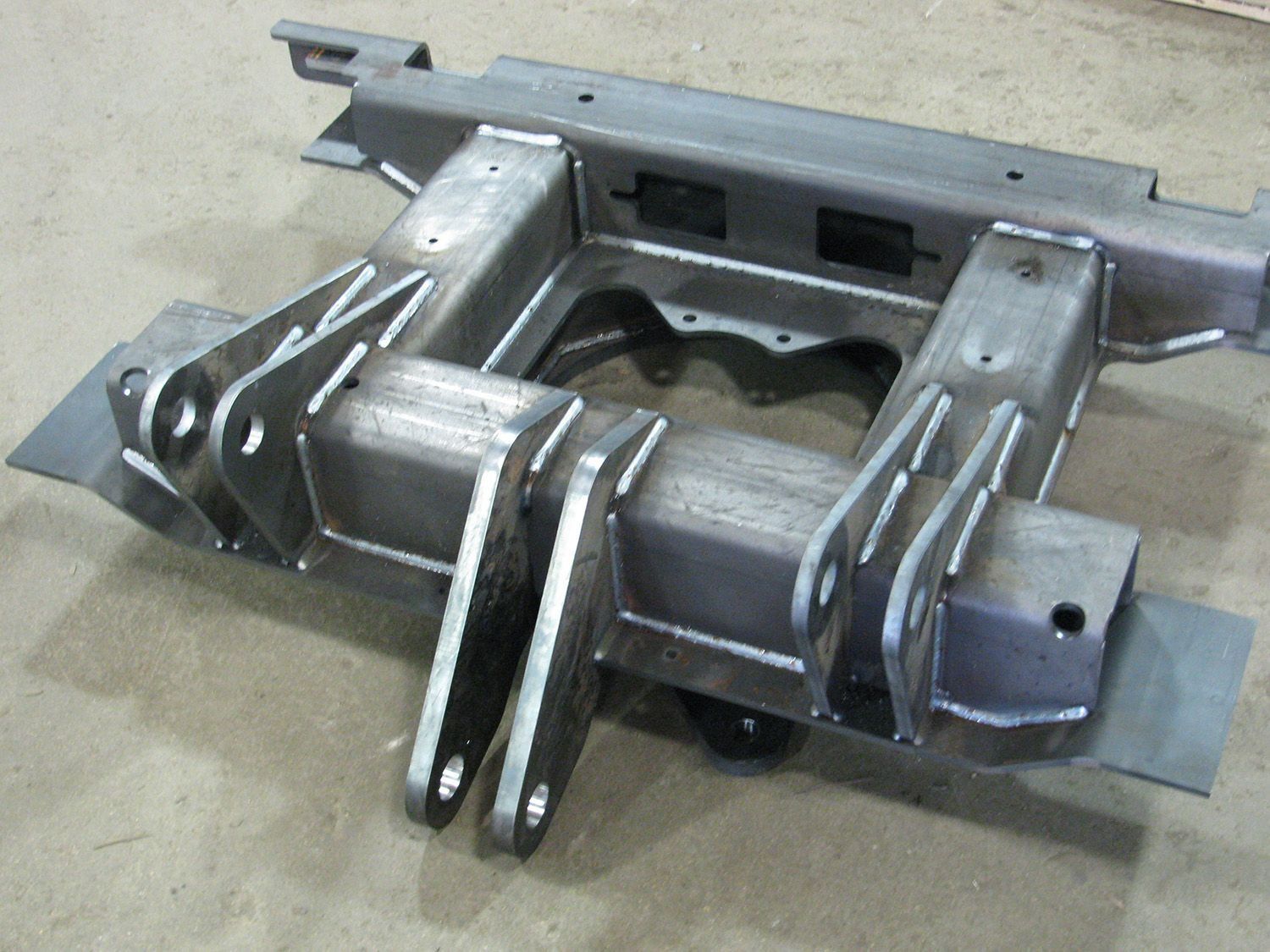 Metal automotive hitch or bumper bracket assembly on a concrete floor