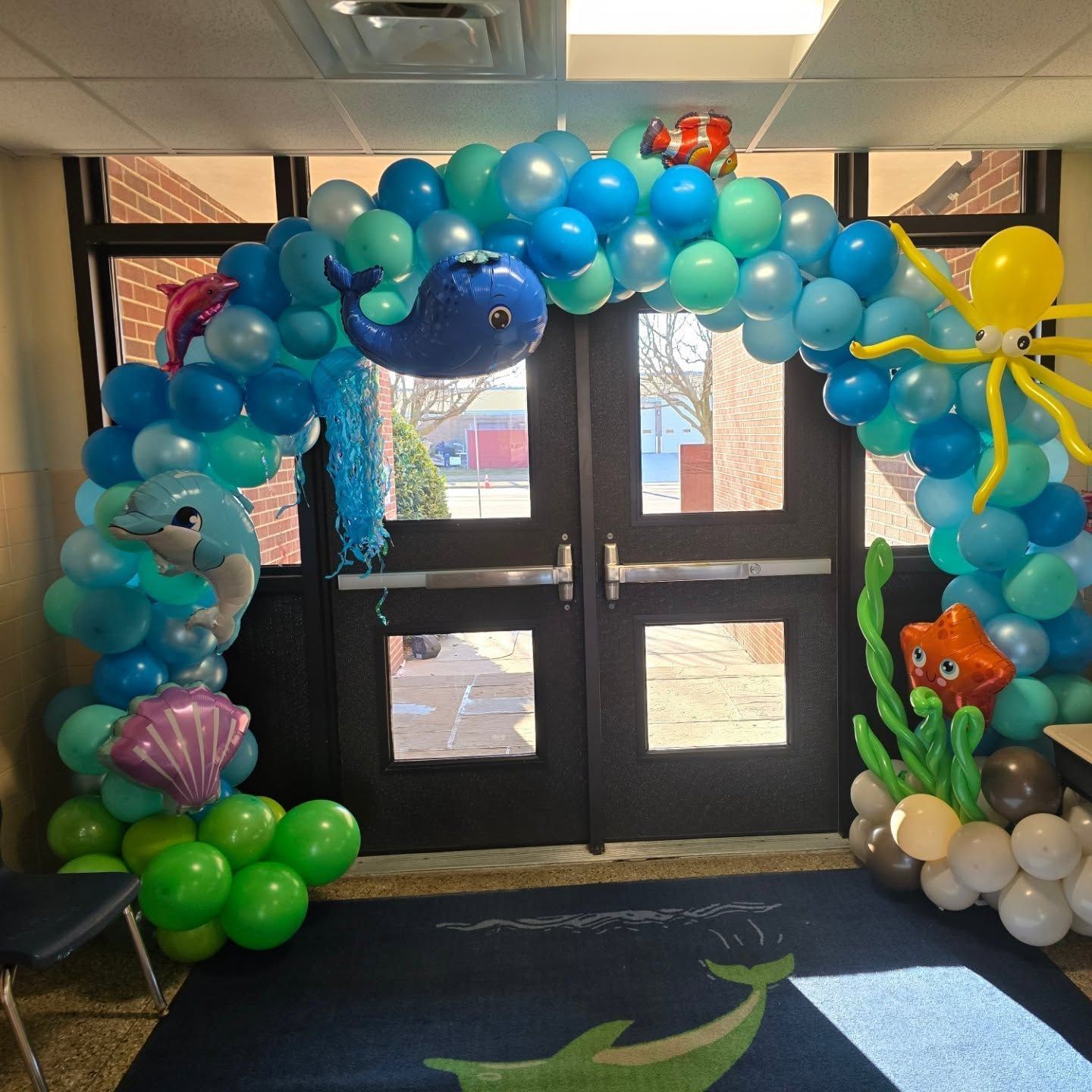 Underwater-themed balloon arch at a building entrance with sea creature decorations