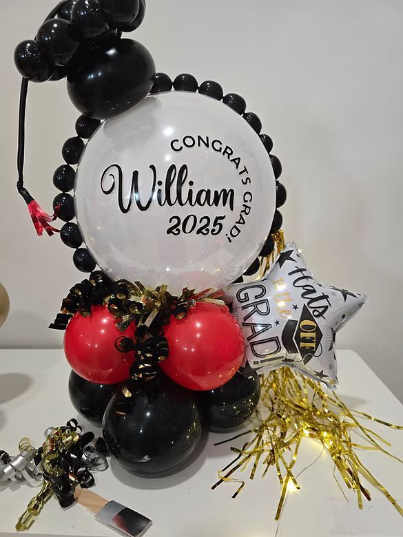 Black, red, and white balloon sculpture with a “William 2025” graduation sign and tassel decoration