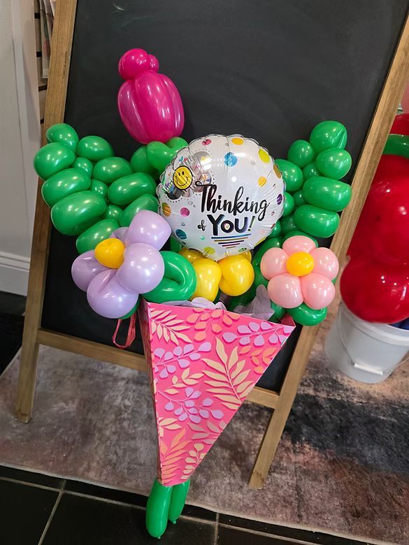 Balloon bouquet with “Thinking of You” card in pink floral cone stand